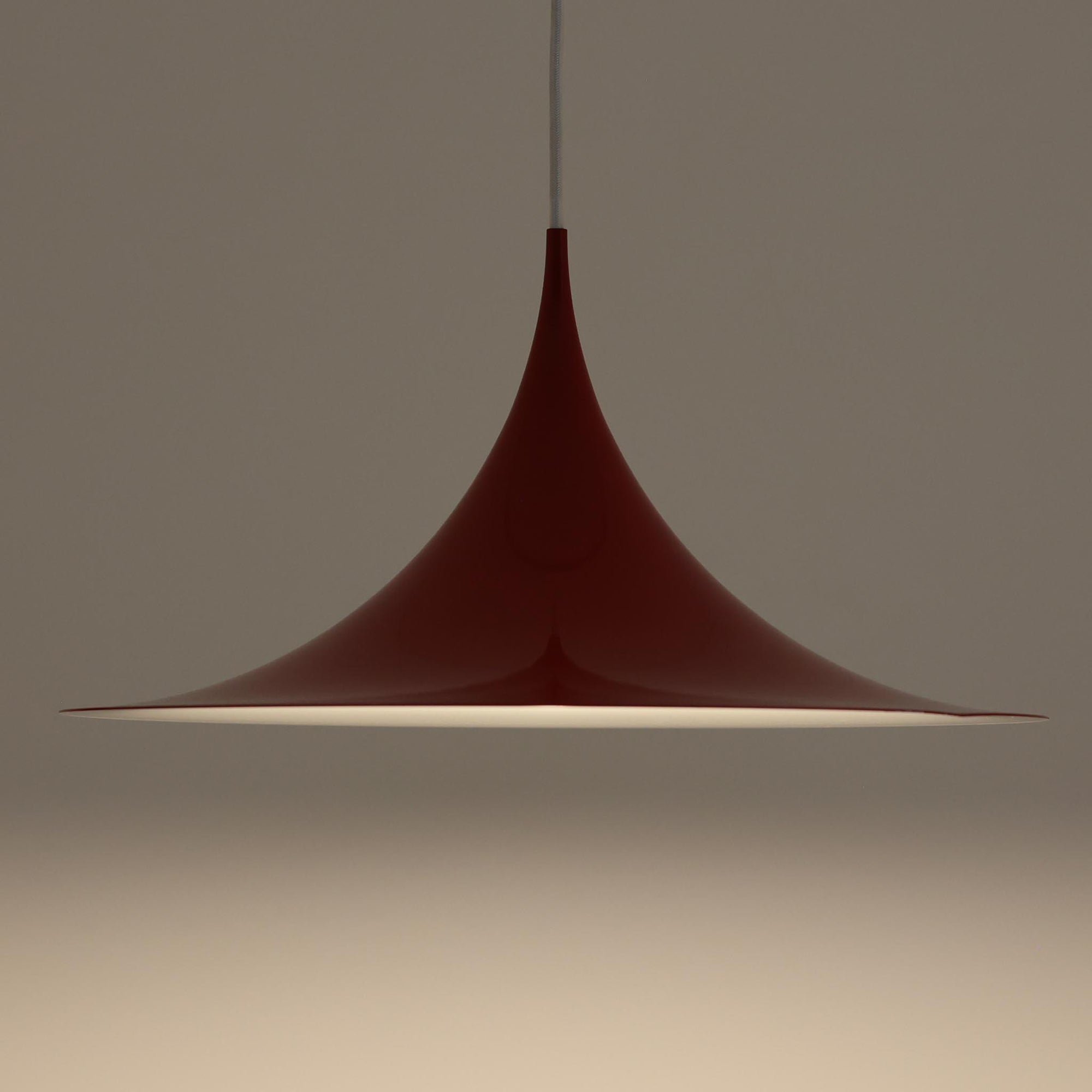 Claus Bonderup & Torsten Thorupによってデザインされ、Fog & Morup社から発表されたペンダントライト「Semi」です。直径47cmの存在感あるサイズと、シャープに絞り込まれた独特のフォルムが特徴です。鮮やかなレッドのカラーが空間にアクセントを与え、点灯時には下方向へ集中的に光を届けつつ、周囲をやわらかく照らします。1960年代に誕生したモダンデザインの象徴的な作品で、シンプルながらも彫刻的な美しさを備えています。北欧ビンテージならではの上質な佇まいで、ダイニングやリビングに華やかな雰囲気を添える一灯です。