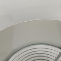 Arne JacobsenがLouis Poulsenのためにデザインした「AJ Royal 370」ペンダントライトです。直径37cmのサイズで、段階的に重なる上部シェードと、下面を覆うアクリルディフューザーによって光が柔らかく拡散し、均一で心地よい明かりを提供します。アルミとスチールの堅牢な構造に加え、シンプルかつモダンなフォルムが空間に洗練された印象を与えます。ダイニングやリビングに適した存在感ある照明で、北欧デザインを象徴するビンテージアイテムです。現行モデルでは展開されていないライトグレーのカラーは、当時のオリジナル品ならではの希少な仕様であり、コレクターズアイテムとしても高い価値を持っています。
