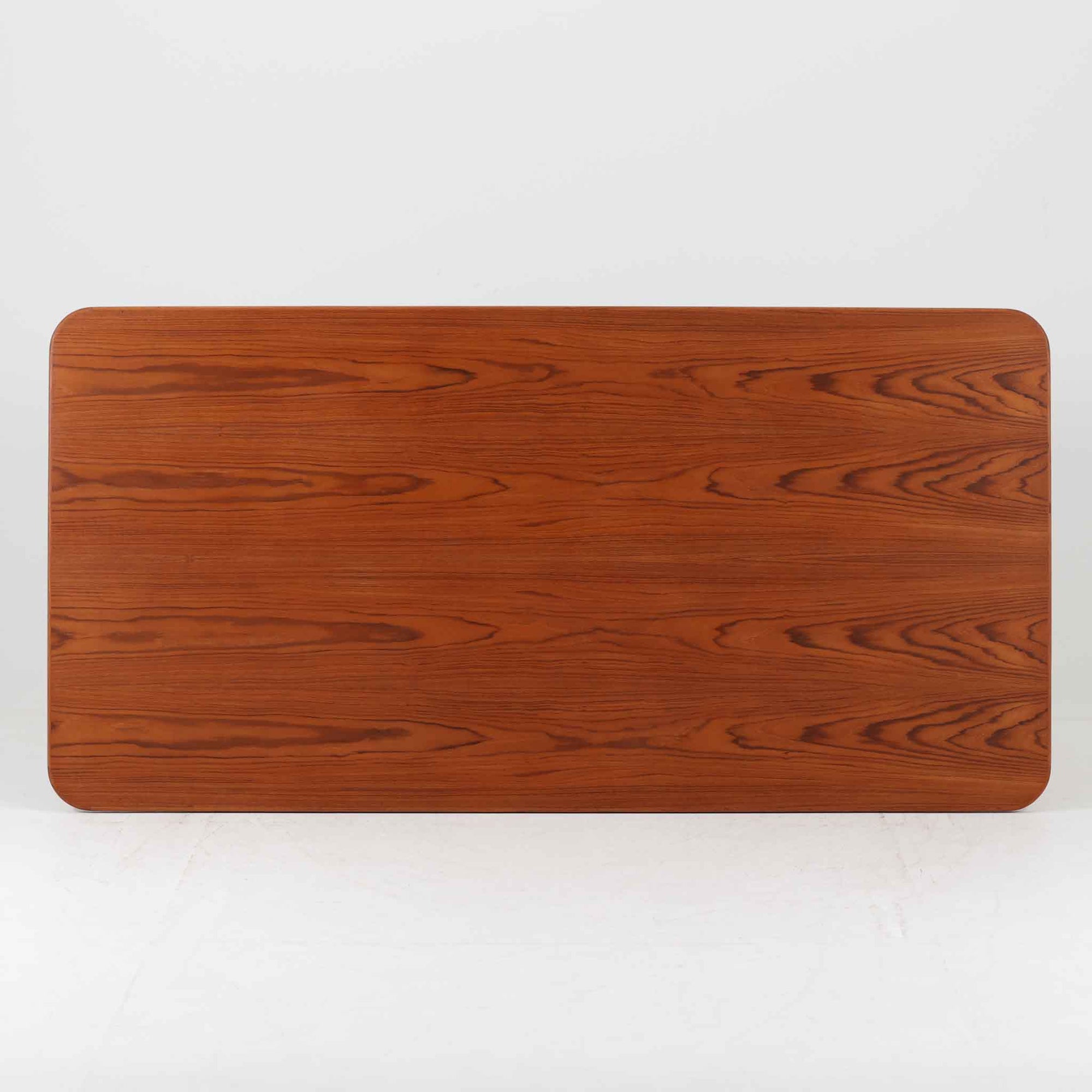 Borge Mogensenがデザインし、Soborg Mobler社より製造されたダイニングテーブル「BM1160」ハンティングテーブルです。現行品はカール・ハンセン社からも展開されていますが、こちらはSoborg社製造によるビンテージ品で、現在では入手が難しいチーク材仕様となっています。幅180cmと現行品よりややコンパクトなサイズ感で、日本の住空間にも取り入れやすい設計です。豊かな木目を持つチーク材の天板に、脚部を支える真鍮製クロスバーを組み合わせることで、堅牢さと美しさを兼ね備えています。角には滑らかな曲線が施され、温かみのある印象を添えつつ、家族や来客を迎える食卓として十分な広さを誇ります。真鍮パーツは構造的強度を高めると同時にビンテージらしい上質なアクセントとなり、シンプルでありながら存在感ある佇まいを演出。北欧家具ならではの実用性とデザイン性が息づき、年月を重ねることでさらに素材の風合いが深まり、空間を豊かに彩ります。