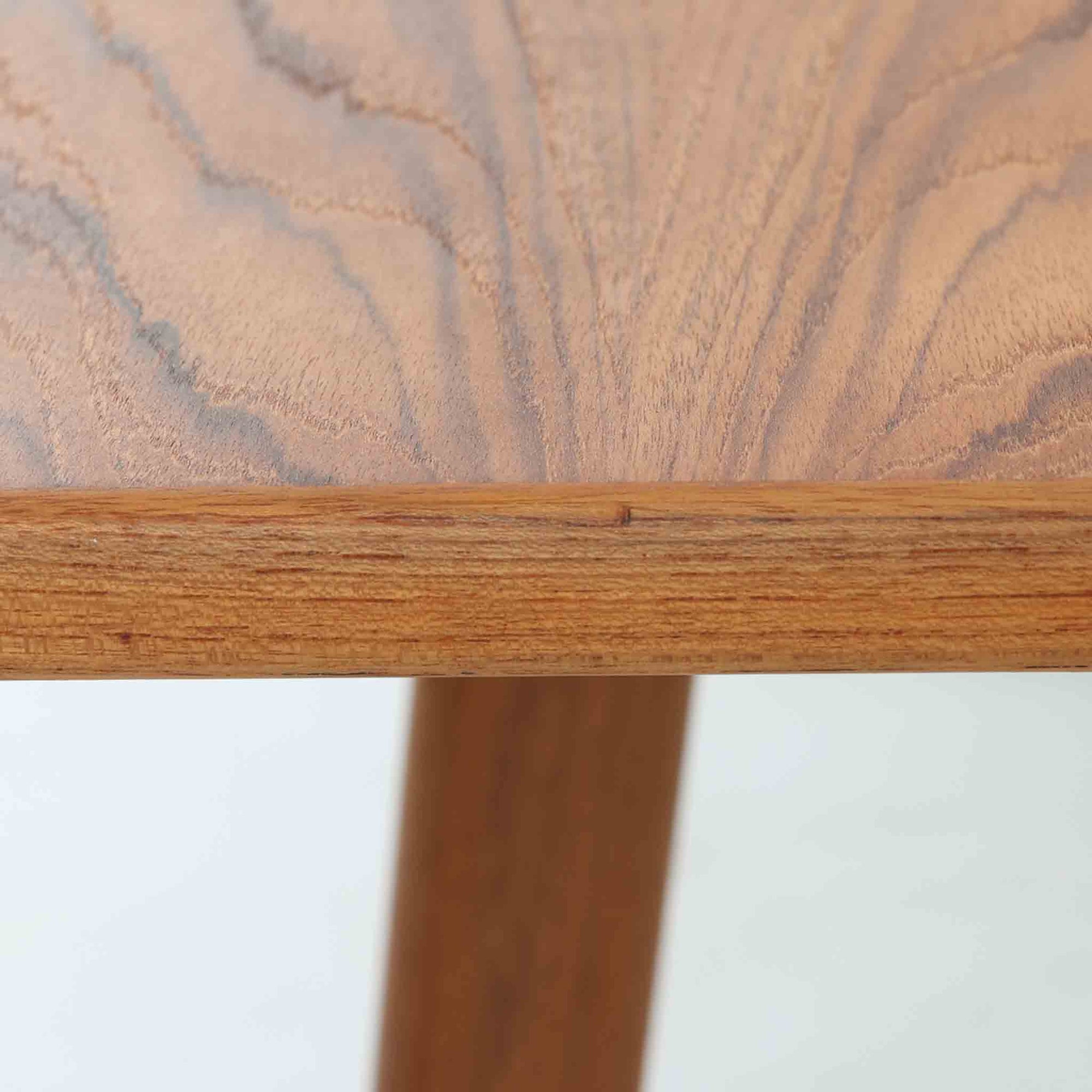 Borge Mogensenがデザインし、Soborg Mobler社より製造されたダイニングテーブル「BM1160」ハンティングテーブルです。現行品はカール・ハンセン社からも展開されていますが、こちらはSoborg社製造によるビンテージ品で、現在では入手が難しいチーク材仕様となっています。幅180cmと現行品よりややコンパクトなサイズ感で、日本の住空間にも取り入れやすい設計です。豊かな木目を持つチーク材の天板に、脚部を支える真鍮製クロスバーを組み合わせることで、堅牢さと美しさを兼ね備えています。角には滑らかな曲線が施され、温かみのある印象を添えつつ、家族や来客を迎える食卓として十分な広さを誇ります。真鍮パーツは構造的強度を高めると同時にビンテージらしい上質なアクセントとなり、シンプルでありながら存在感ある佇まいを演出。北欧家具ならではの実用性とデザイン性が息づき、年月を重ねることでさらに素材の風合いが深まり、空間を豊かに彩ります。