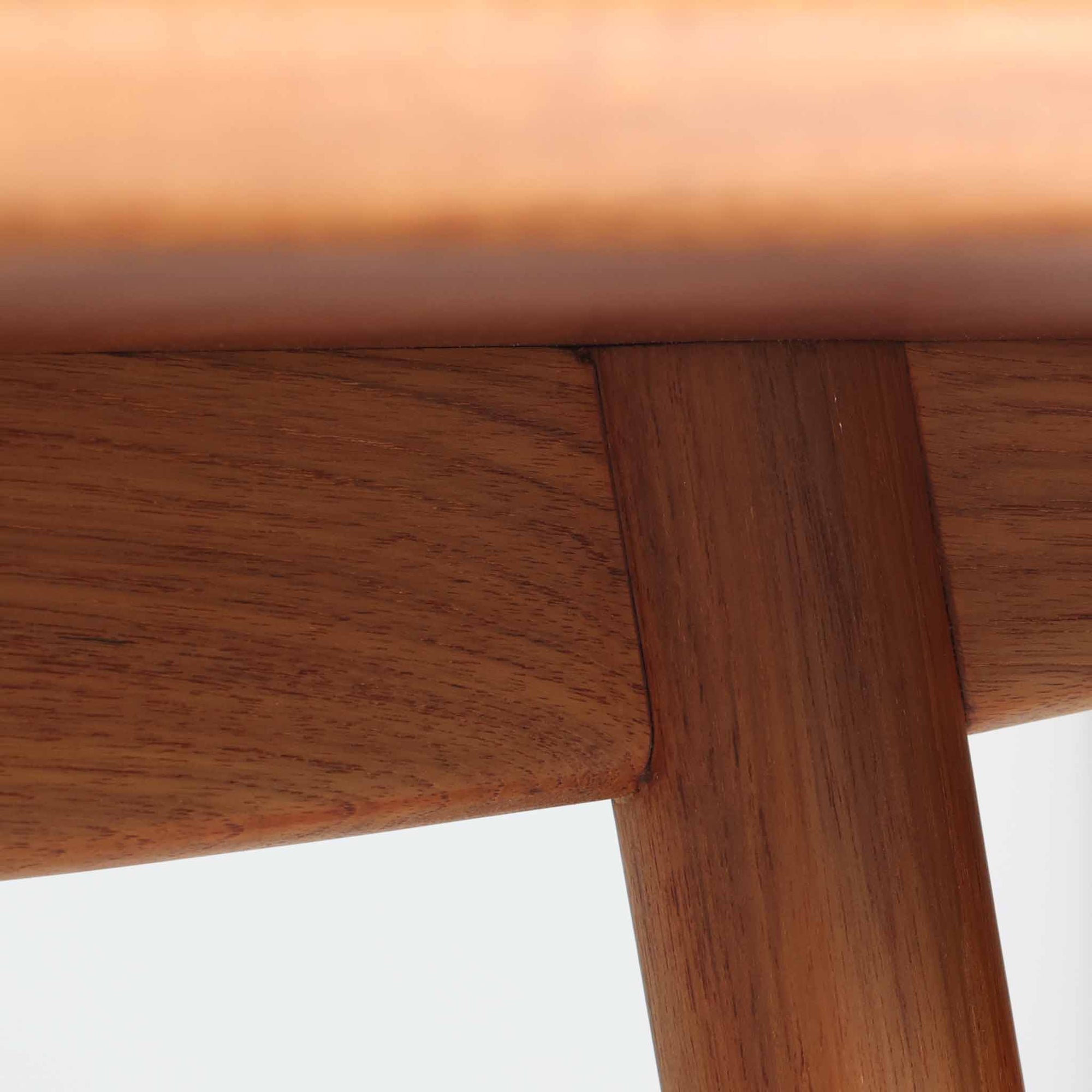 Borge Mogensenがデザインし、Soborg Mobler社より製造されたダイニングテーブル「BM1160」ハンティングテーブルです。現行品はカール・ハンセン社からも展開されていますが、こちらはSoborg社製造によるビンテージ品で、現在では入手が難しいチーク材仕様となっています。幅180cmと現行品よりややコンパクトなサイズ感で、日本の住空間にも取り入れやすい設計です。豊かな木目を持つチーク材の天板に、脚部を支える真鍮製クロスバーを組み合わせることで、堅牢さと美しさを兼ね備えています。角には滑らかな曲線が施され、温かみのある印象を添えつつ、家族や来客を迎える食卓として十分な広さを誇ります。真鍮パーツは構造的強度を高めると同時にビンテージらしい上質なアクセントとなり、シンプルでありながら存在感ある佇まいを演出。北欧家具ならではの実用性とデザイン性が息づき、年月を重ねることでさらに素材の風合いが深まり、空間を豊かに彩ります。