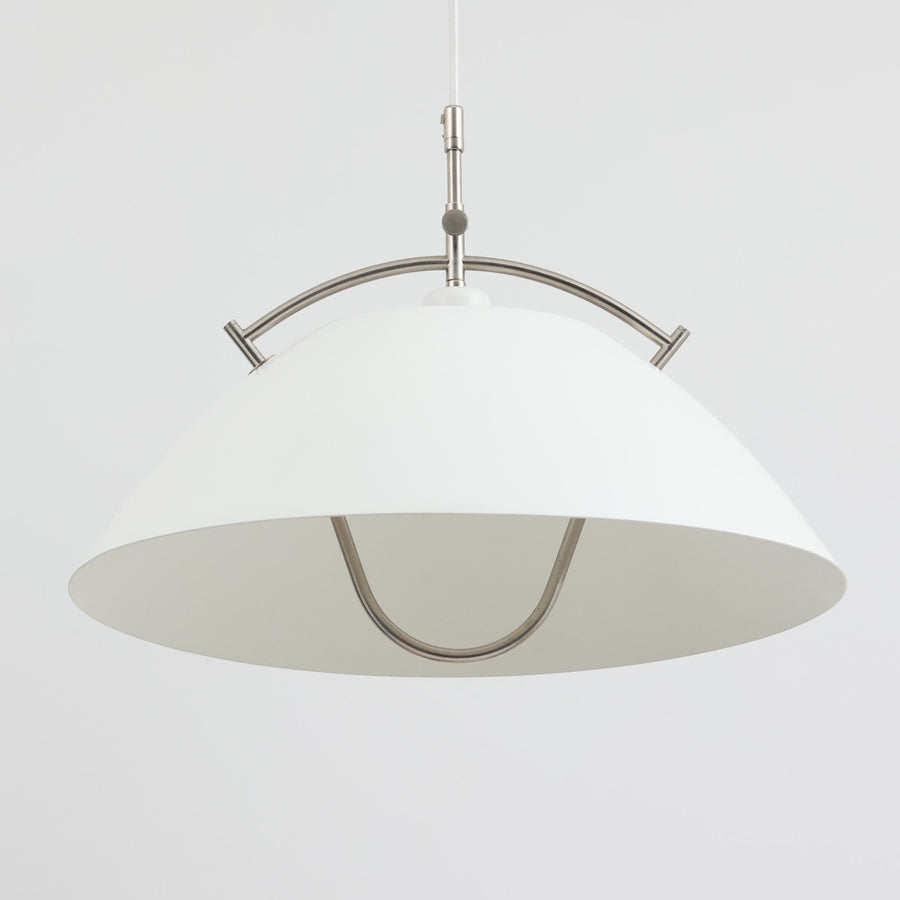Pandul（パンドゥル）社が正規製造している、ハンス・J・ウェグナー（Hans J. Wegner）デザインのペンダントライト「JH604」です。1960年代にLouis Poulsen（ルイスポールセン）社で製造されていたモデルで、ウェグナーが自邸のためにデザインしたことでも知られています。直径50cmの存在感あるフォルムと、アルミ製シェードとステンレス製アームによる軽やかで堅牢な構造は、北欧デザインらしい機能美を体現。点灯時には下方向だけでなくシェード上部の隙間からも光が柔らかく漏れ、空間に奥行きを与えます。Pandulは1982年にデンマークで設立され、Louis Poulsenから受け継いだ名作を当時のデザインと品質を尊重して製造しているブランドです。なお、本品はプラスチック製コードリールが欠品しておりますが、全体として良好なコンディションを保っています。ヴィンテージデザインの魅力と現行製造ならではの安心感を兼ね備えた、北欧デザインを象徴する一灯です。