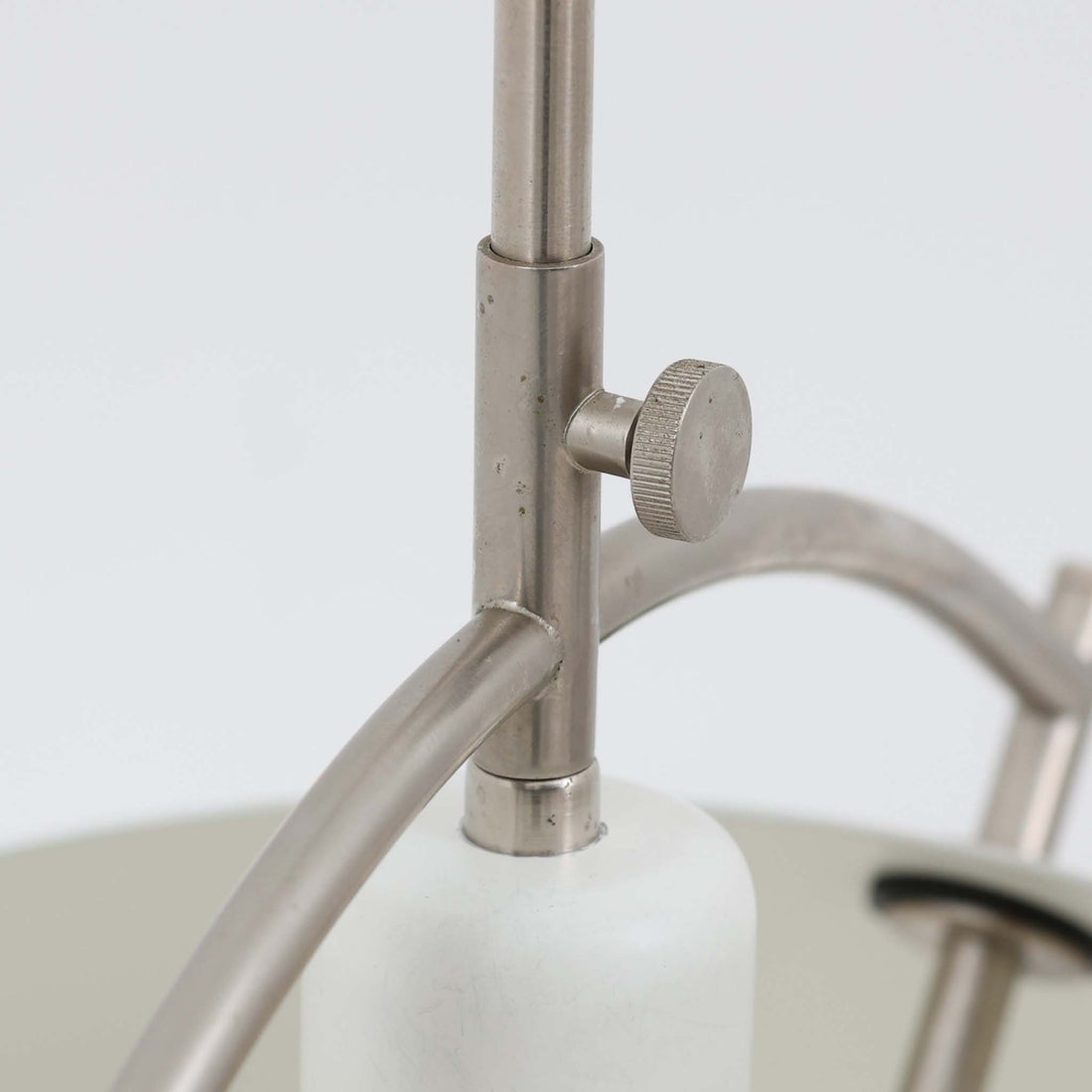 Pandul（パンドゥル）社が正規製造している、ハンス・J・ウェグナー（Hans J. Wegner）デザインのペンダントライト「JH604」です。1960年代にLouis Poulsen（ルイスポールセン）社で製造されていたモデルで、ウェグナーが自邸のためにデザインしたことでも知られています。直径50cmの存在感あるフォルムと、アルミ製シェードとステンレス製アームによる軽やかで堅牢な構造は、北欧デザインらしい機能美を体現。点灯時には下方向だけでなくシェード上部の隙間からも光が柔らかく漏れ、空間に奥行きを与えます。Pandulは1982年にデンマークで設立され、Louis Poulsenから受け継いだ名作を当時のデザインと品質を尊重して製造しているブランドです。なお、本品はプラスチック製コードリールが欠品しておりますが、全体として良好なコンディションを保っています。ヴィンテージデザインの魅力と現行製造ならではの安心感を兼ね備えた、北欧デザインを象徴する一灯です。