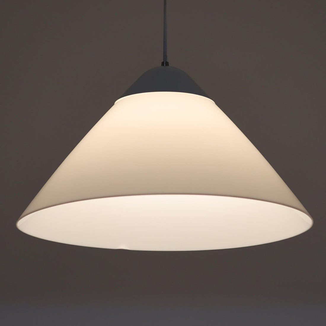 Hans J. WegnerによるデザインでLouis Poulsen社から発表されたペンダントライト「Opala」直径52cmです。アクリル製シェードの軽やかな円錐形フォルムは空間にモダンで柔らかな印象を与え、点灯時には全体が美しく発光しつつ下方向と周囲に心地よい明かりを広げます。ホテルや公共施設でも採用された名作で、北欧デザインらしいシンプルかつ機能的な美しさを備えています。現行品はPandul社より販売されていますが、本品は1970年代にLouis Poulsen社から発表され、1980年代に販売を終えた希少なオリジナルモデルであり、ビンテージならではの存在感を放つ一品です。ダメージが大きいため価格に反映しています。