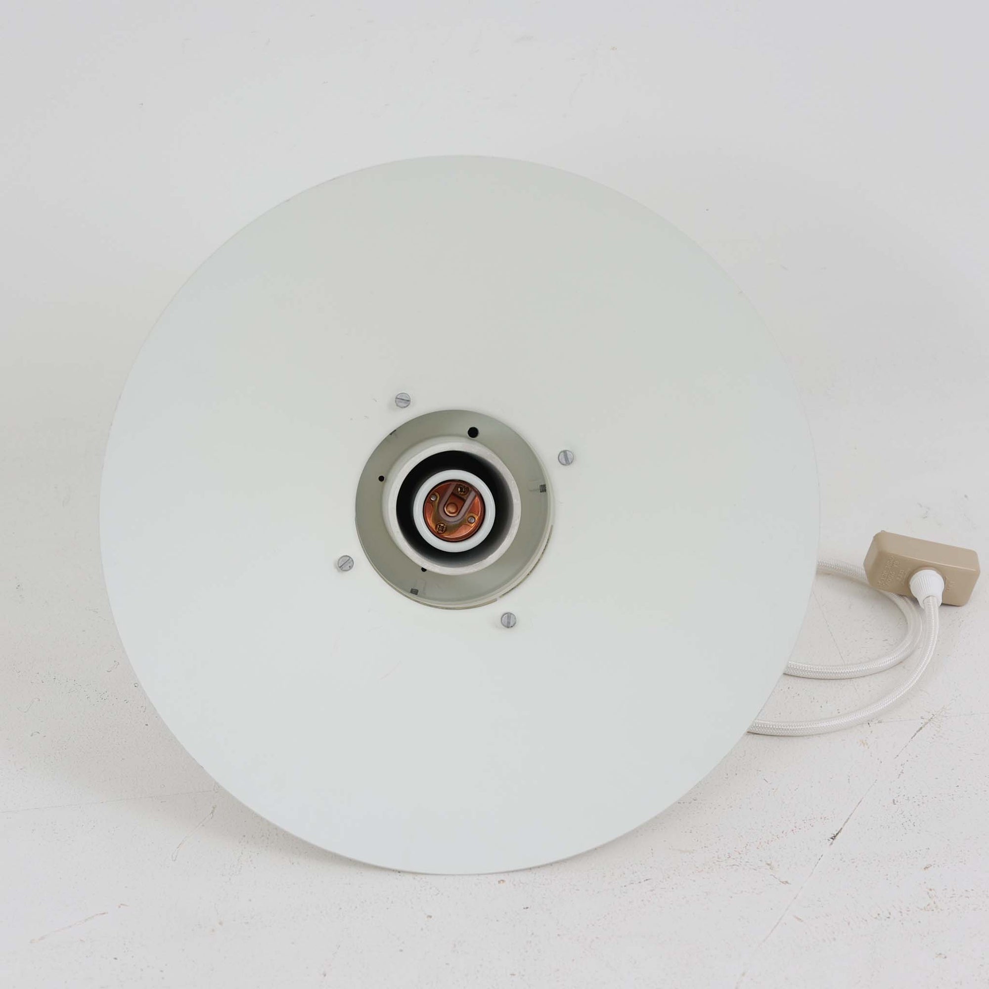 Alfred HomannとOle V. Kjaerによってデザインされ、Louis Poulsen社から製造されたペンダントライト「Nyhavn」は、直径31cmのコンパクトなサイズながらも力強い存在感を放ちます。メタル素材を用いたシェードとガード付きの構造は、港町の灯りを思わせる堅牢で印象的なデザインで、光源を柔らかく拡散しつつ下方をしっかりと照らします。シンプルな中に建築的な要素を感じさせる造形は、ダイニングや玄関、カウンター上など幅広い空間で活躍し、北欧ビンテージならではの実用性と希少性を兼ね備えています。