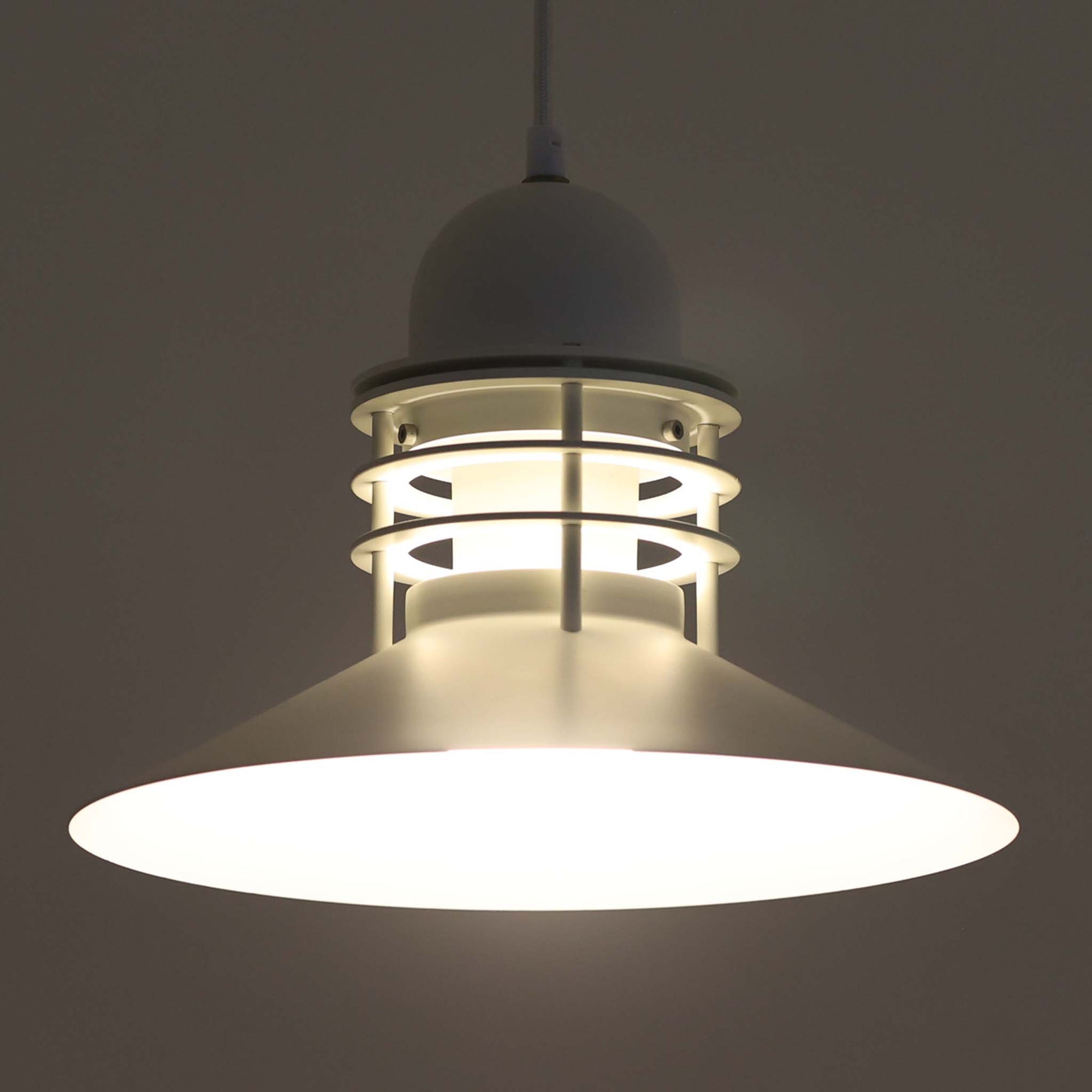 Alfred HomannとOle V. Kjaerによってデザインされ、Louis Poulsen社から製造されたペンダントライト「Nyhavn」は、直径31cmのコンパクトなサイズながらも力強い存在感を放ちます。メタル素材を用いたシェードとガード付きの構造は、港町の灯りを思わせる堅牢で印象的なデザインで、光源を柔らかく拡散しつつ下方をしっかりと照らします。シンプルな中に建築的な要素を感じさせる造形は、ダイニングや玄関、カウンター上など幅広い空間で活躍し、北欧ビンテージならではの実用性と希少性を兼ね備えています。