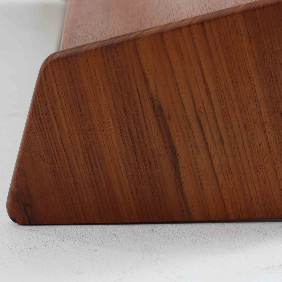 デンマークの家具メーカー、Aksel Kjersgaard（アクセル・キアスゴー）によるチーク無垢材のウォールシェルフです。無駄を削ぎ落とした直線的なデザインと、面取りされた角の柔らかさが美しく調和し、上質な北欧モダンを感じさせます。細やかな木目が際立つチーク無垢材は、経年とともに深みを増し、時間とともに味わいを楽しめます。本や小物をディスプレイするだけでなく、玄関や寝室の壁面収納としても便利。職人技が光る洗練されたシェルフです。