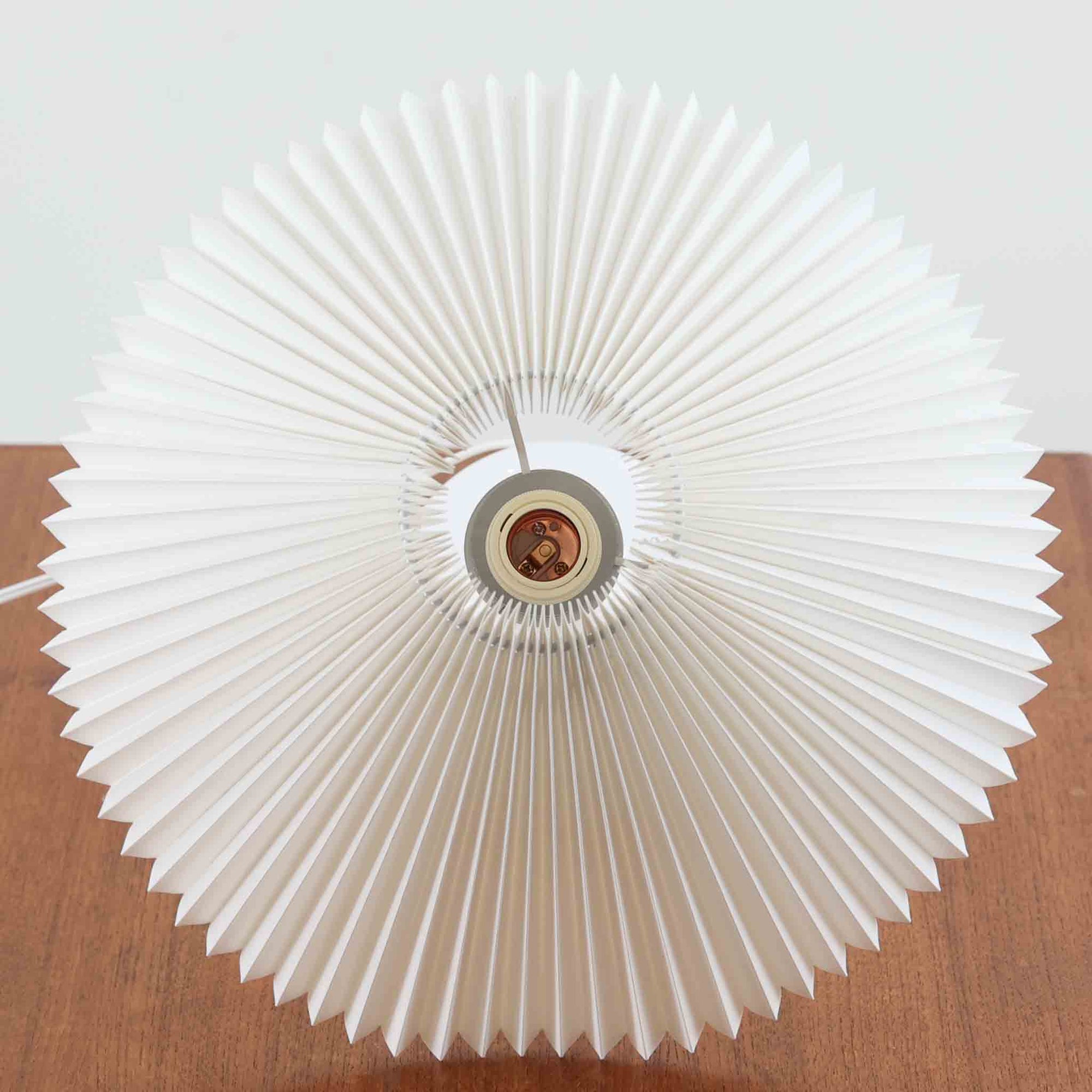 Esben KlintがLe Klintのためにデザインした「Model 311」テーブルランプです。高さ48cmの程よいサイズ感で、ガラスベースと真鍮パーツの組み合わせが美しい一品で、ベース部分はオリジナルです。シェードは後年に交換されたもので、LE KLINT社製のオリジナルではございませんが、同様にプラスチックシートを用いて製作されており、雰囲気を損なうことなく調和しています。点灯時には柔らかな光が広がり、落ち着いた雰囲気を演出。シンプルながらも存在感のあるデザインは、リビングやベッドサイドのアクセントとして最適です。デンマークデザインの伝統と職人技が息づくビンテージ照明です。