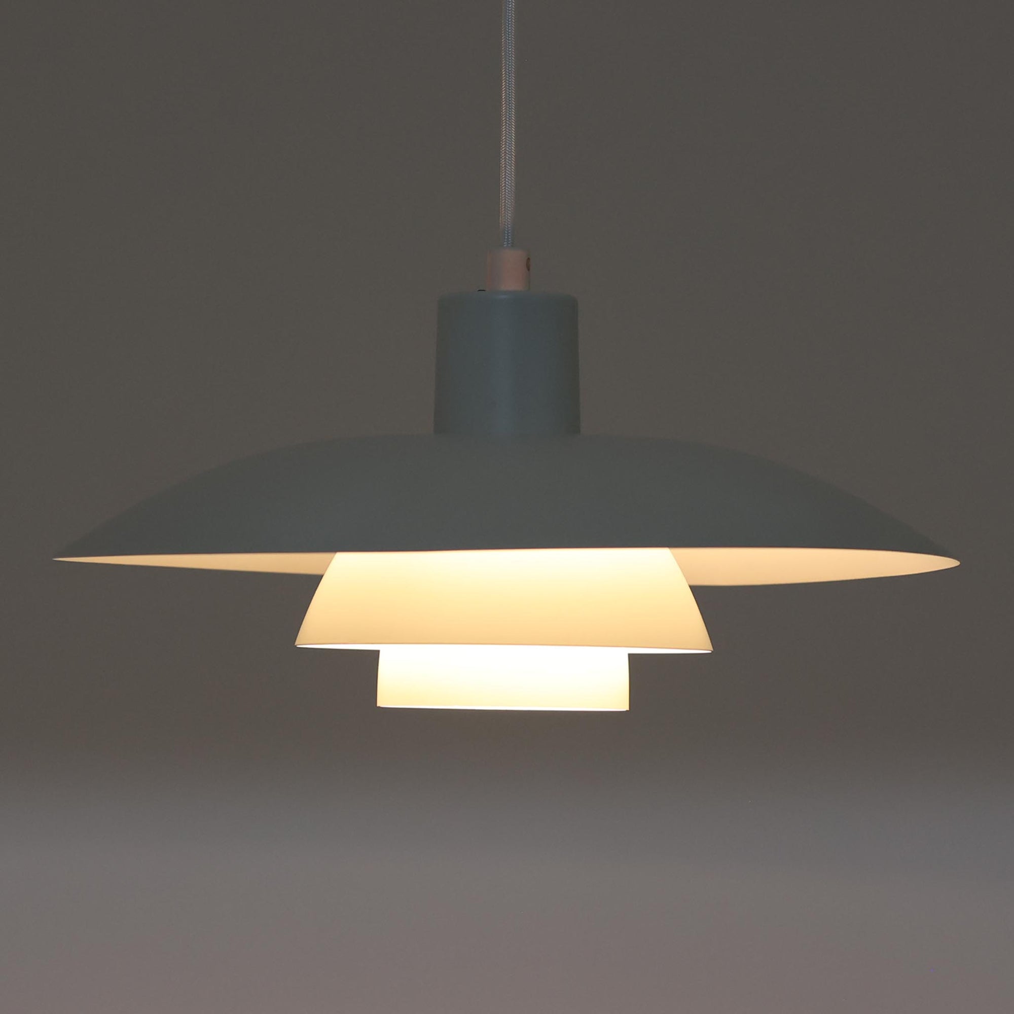 北欧より買い付けたLouis Poulsen社製「PH4」は、Poul Henningsenによる名作照明で、直径40cmの程よいサイズとアルミの軽やかな質感が魅力です。PH5と並ぶ人気を誇り、3枚シェード構造が光を柔らかく拡散し落ち着いた空間を演出します。経年の風合いも楽しめ、ダイニングやリビング、書斎や寝室まで幅広く活躍するビンテージ品です。