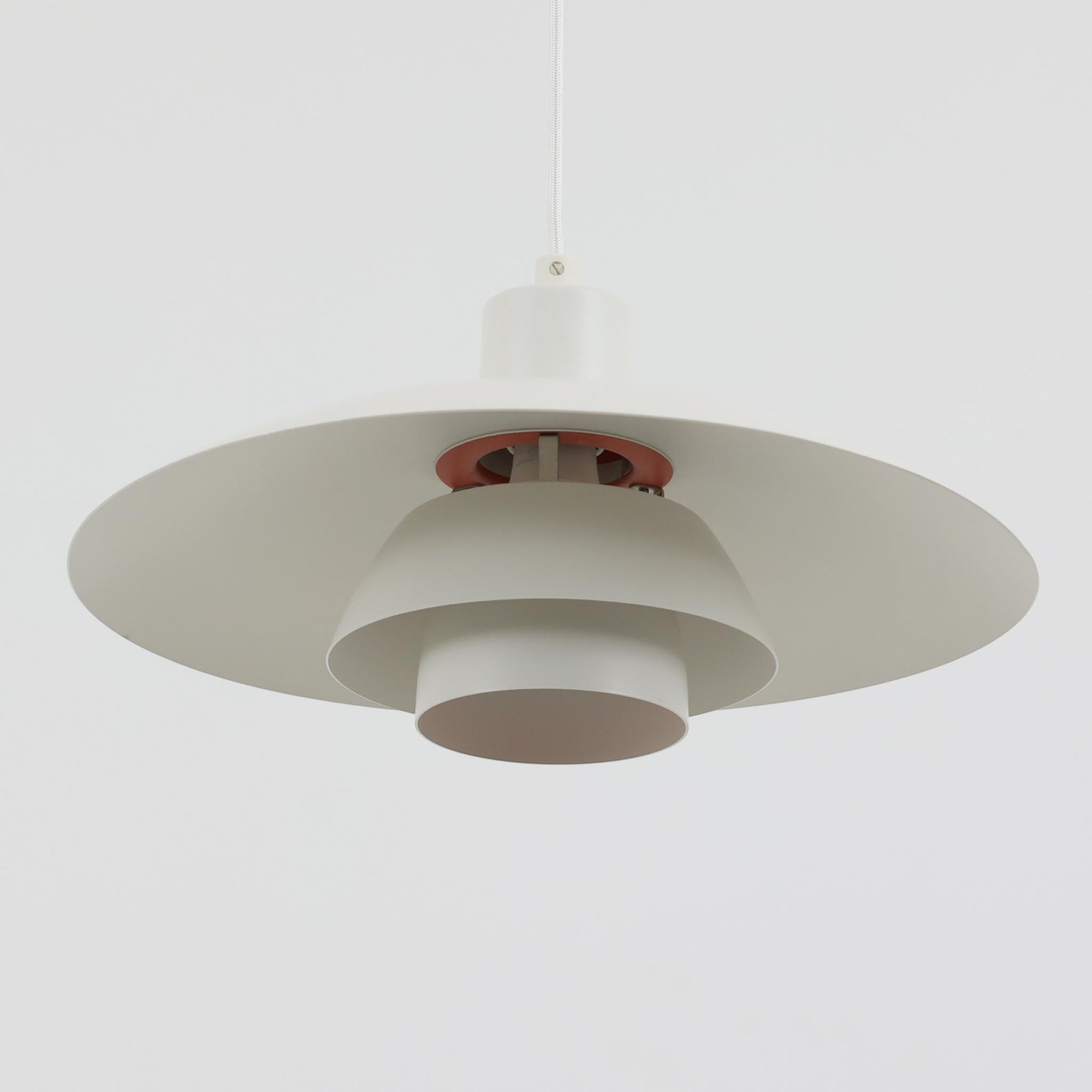 北欧より買い付けたLouis Poulsen社製「PH4」は、Poul Henningsenによる名作照明で、直径40cmの程よいサイズとアルミの軽やかな質感が魅力です。PH5と並ぶ人気を誇り、3枚シェード構造が光を柔らかく拡散し落ち着いた空間を演出します。経年の風合いも楽しめ、ダイニングやリビング、書斎や寝室まで幅広く活躍するビンテージ品です。