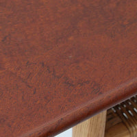 Hans J. WegnerがAndreas Tuckのために手掛けたAT10センターテーブルは、チーク材の天板にオーク材のフレーム、ラタン張りの棚板を組み合わせた、素材使いの美しさが際立つ北欧ビンテージの名作です。直線を基調とした端正なプロポーションの中に、天板縁のやわらかな丸みや、軽やかに抜け感を生むラタン棚が配され、視覚的にも圧迫感のない佇まいに仕上げられています。幅160cmのゆとりあるサイズはリビングの主役として使いやすく、雑誌や小物を収納できる実用性も備え、経年変化により深みを増した木肌が空間に上質な落ち着きをもたらします。なお、天板には反りがあり、大きめのへこみも見られるため、その点を考慮した価格設定としておりますが、ご使用には問題なく、ビンテージならではの風合いとしてご理解いただける方におすすめの一台です。