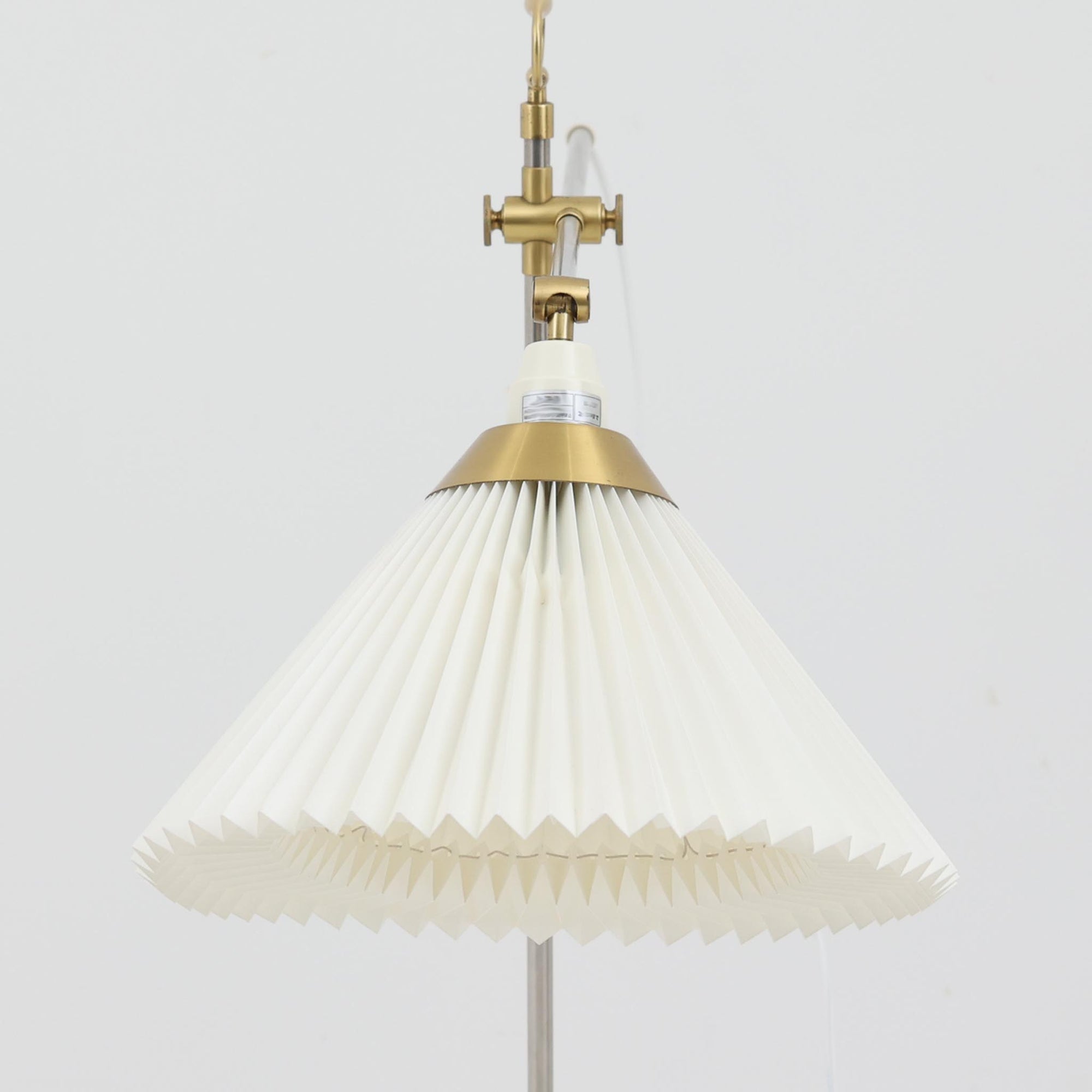 Esben Klintによるデザインで、Le Klint（レ・クリント）より発表されたテーブルランプModel 319です。真鍮とスチールを組み合わせた構造は、堅牢さと洗練された印象を兼ね備え、ハンドメイドのプリーツシェードが柔らかい光を拡散します。高さ75cmの程よいサイズ感とクロスバー構造による可動性が特徴で、デスクやリビングでの読書灯としても実用的です。経年による真鍮の風合いがビンテージらしい魅力を引き立て、空間にクラシカルで上質な雰囲気をもたらします。