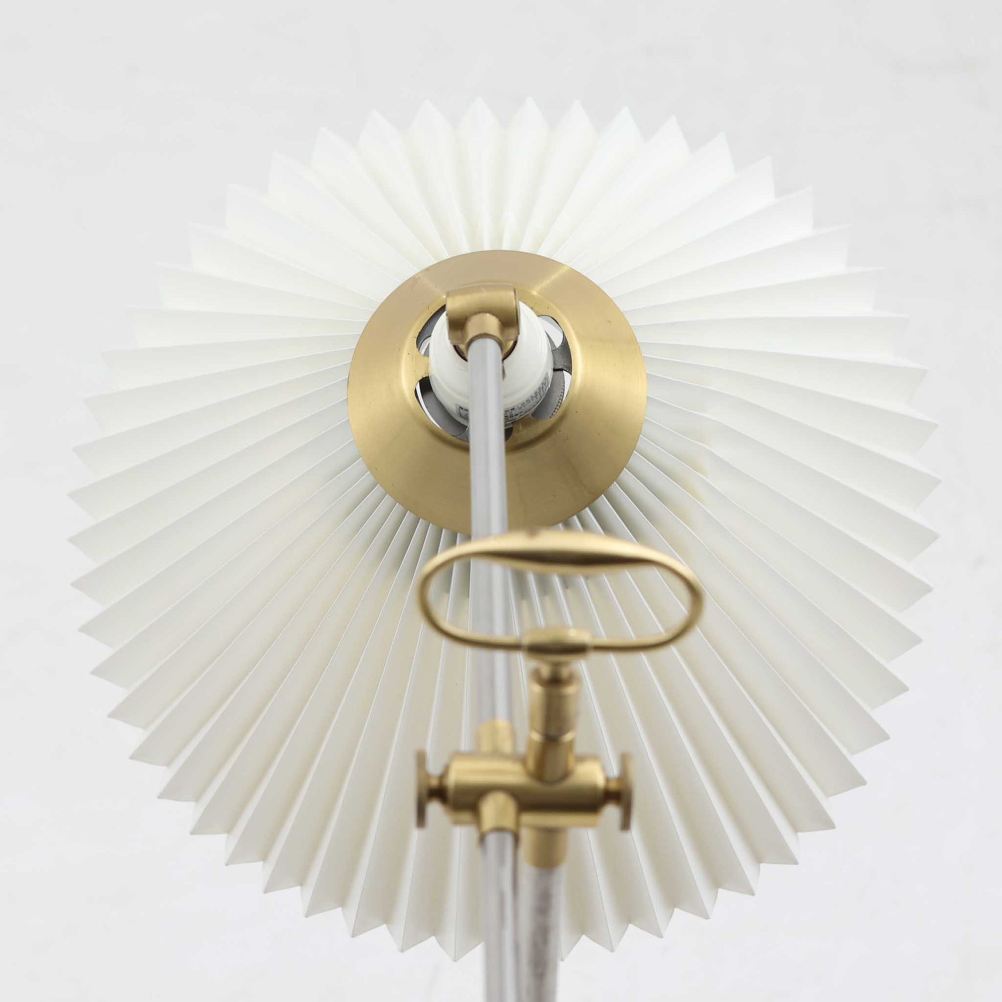 Esben Klintによるデザインで、Le Klint（レ・クリント）より発表されたテーブルランプModel 319です。真鍮とスチールを組み合わせた構造は、堅牢さと洗練された印象を兼ね備え、ハンドメイドのプリーツシェードが柔らかい光を拡散します。高さ75cmの程よいサイズ感とクロスバー構造による可動性が特徴で、デスクやリビングでの読書灯としても実用的です。経年による真鍮の風合いがビンテージらしい魅力を引き立て、空間にクラシカルで上質な雰囲気をもたらします。