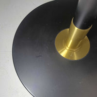 Aage Petersenによるデザインで、Le Klint社より発表されたモデル352のテーブルランプです。高さ62～85cmの昇降機能を備え、使用シーンに合わせて調整可能なのが魅力です。黒塗装のスチール支柱に真鍮パーツがアクセントとなり、プリーツ加工が美しい紙製シェードからは柔らかな光が広がります。特に点灯時にはシェードを透過して漏れる灯りが印象的で、空間を上品に演出します。現在は廃盤となっており、ビンテージ品のみ入手可能なモデルです。