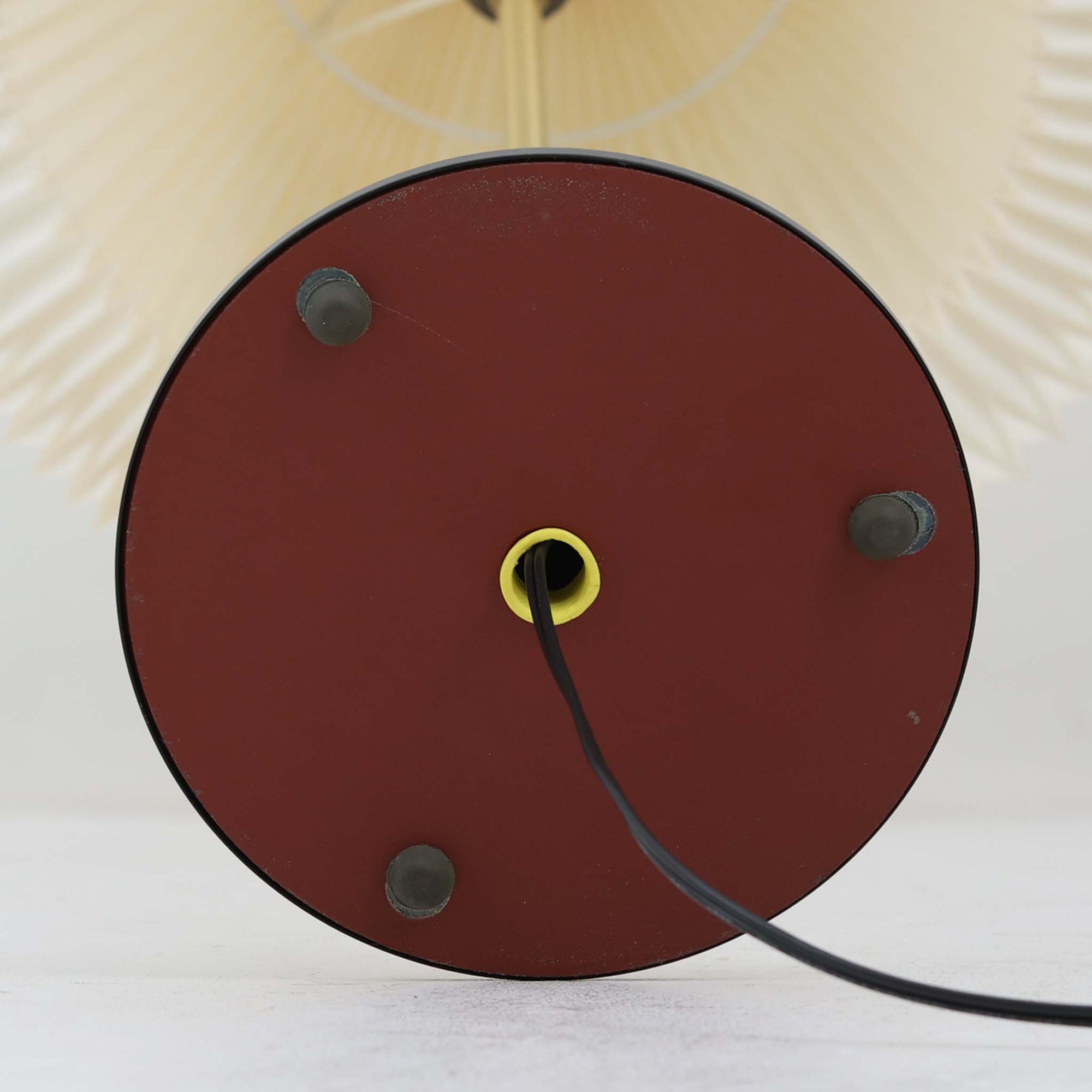 Aage Petersenによるデザインで、Le Klint社より発表されたモデル352のテーブルランプです。高さ62～85cmの昇降機能を備え、使用シーンに合わせて調整可能なのが魅力です。黒塗装のスチール支柱に真鍮パーツがアクセントとなり、プリーツ加工が美しい紙製シェードからは柔らかな光が広がります。特に点灯時にはシェードを透過して漏れる灯りが印象的で、空間を上品に演出します。現在は廃盤となっており、ビンテージ品のみ入手可能なモデルです。