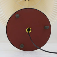 Aage Petersenによるデザインで、Le Klint社より発表されたモデル352のテーブルランプです。高さ62～85cmの昇降機能を備え、使用シーンに合わせて調整可能なのが魅力です。黒塗装のスチール支柱に真鍮パーツがアクセントとなり、プリーツ加工が美しい紙製シェードからは柔らかな光が広がります。特に点灯時にはシェードを透過して漏れる灯りが印象的で、空間を上品に演出します。現在は廃盤となっており、ビンテージ品のみ入手可能なモデルです。