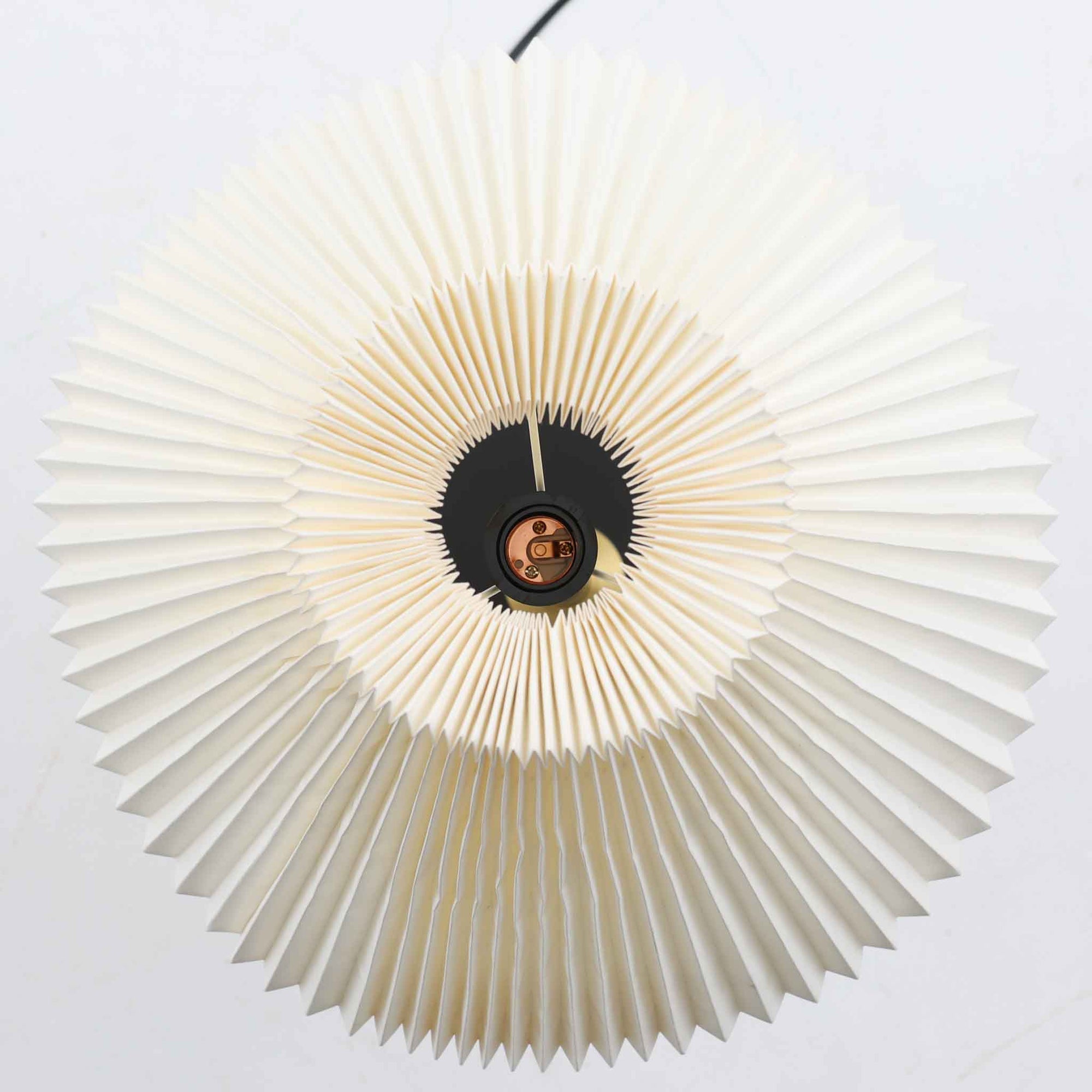 Aage Petersenによるデザインで、Le Klint社より発表されたモデル352のテーブルランプです。高さ62～85cmの昇降機能を備え、使用シーンに合わせて調整可能なのが魅力です。黒塗装のスチール支柱に真鍮パーツがアクセントとなり、プリーツ加工が美しい紙製シェードからは柔らかな光が広がります。特に点灯時にはシェードを透過して漏れる灯りが印象的で、空間を上品に演出します。現在は廃盤となっており、ビンテージ品のみ入手可能なモデルです。