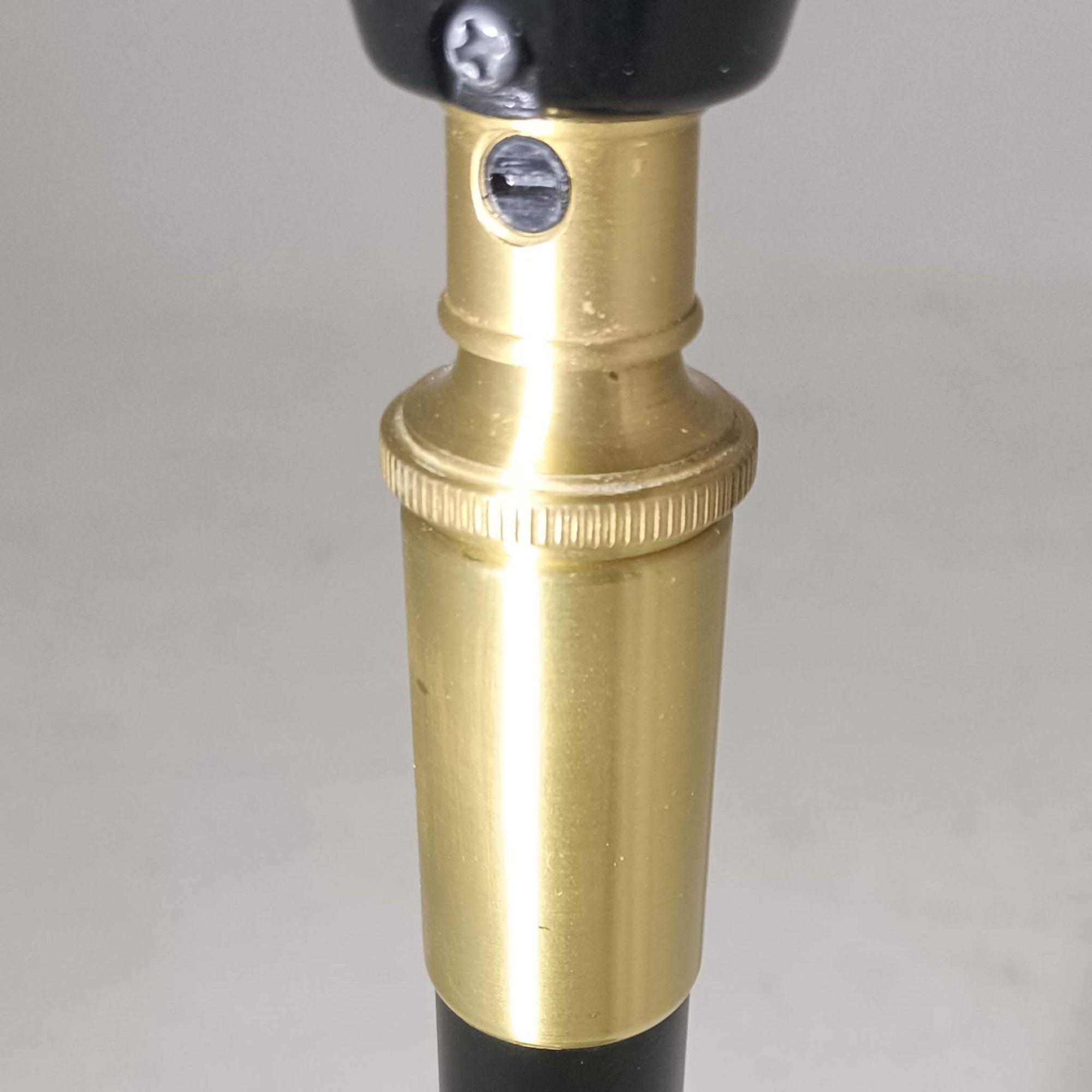 Aage Petersenによるデザインで、Le Klint社より発表されたモデル352のテーブルランプです。高さ62～85cmの昇降機能を備え、使用シーンに合わせて調整可能なのが魅力です。黒塗装のスチール支柱に真鍮パーツがアクセントとなり、プリーツ加工が美しい紙製シェードからは柔らかな光が広がります。特に点灯時にはシェードを透過して漏れる灯りが印象的で、空間を上品に演出します。現在は廃盤となっており、ビンテージ品のみ入手可能なモデルです。