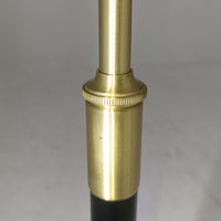 Aage Petersenによるデザインで、Le Klint社より発表されたモデル352のテーブルランプです。高さ62～85cmの昇降機能を備え、使用シーンに合わせて調整可能なのが魅力です。黒塗装のスチール支柱に真鍮パーツがアクセントとなり、プリーツ加工が美しい紙製シェードからは柔らかな光が広がります。特に点灯時にはシェードを透過して漏れる灯りが印象的で、空間を上品に演出します。現在は廃盤となっており、ビンテージ品のみ入手可能なモデルです。