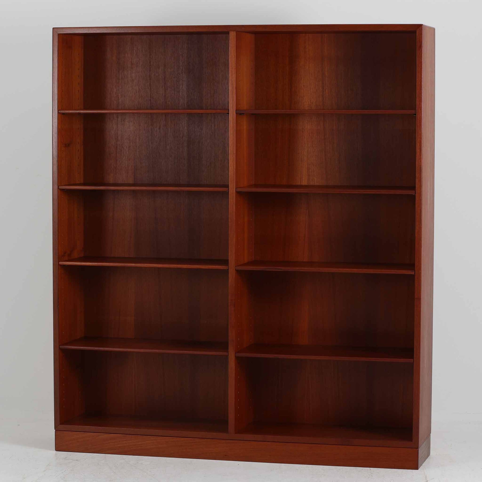 デンマークを代表するデザイナー、Borge Mogensen（ボーエ・モーエンセン）によるFDB社製のチーク材ブックシェルフです。無駄を削ぎ落とした直線的なフォルムと、シンプルで機能的なデザインがモーエンセンらしい魅力を感じさせます。棚板は高さ調整が可能で、収納するものに合わせて柔軟にレイアウトを変えることができます。チークの豊かな木目と深みのある色合いが上品な印象を与え、経年により増した艶や質感も味わい深い一点です。台輪部分までチーク材が使用された希少なタイプで、素材の統一感と高級感が際立ちます。リビングでの書籍収納はもちろん、オブジェや陶器を飾るディスプレイシェルフとしても活躍する北欧ビンテージ家具です。