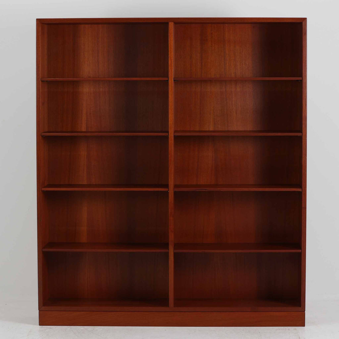 デンマークを代表するデザイナー、Borge Mogensen（ボーエ・モーエンセン）によるFDB社製のチーク材ブックシェルフです。無駄を削ぎ落とした直線的なフォルムと、シンプルで機能的なデザインがモーエンセンらしい魅力を感じさせます。棚板は高さ調整が可能で、収納するものに合わせて柔軟にレイアウトを変えることができます。チークの豊かな木目と深みのある色合いが上品な印象を与え、経年により増した艶や質感も味わい深い一点です。台輪部分までチーク材が使用された希少なタイプで、素材の統一感と高級感が際立ちます。リビングでの書籍収納はもちろん、オブジェや陶器を飾るディスプレイシェルフとしても活躍する北欧ビンテージ家具です。