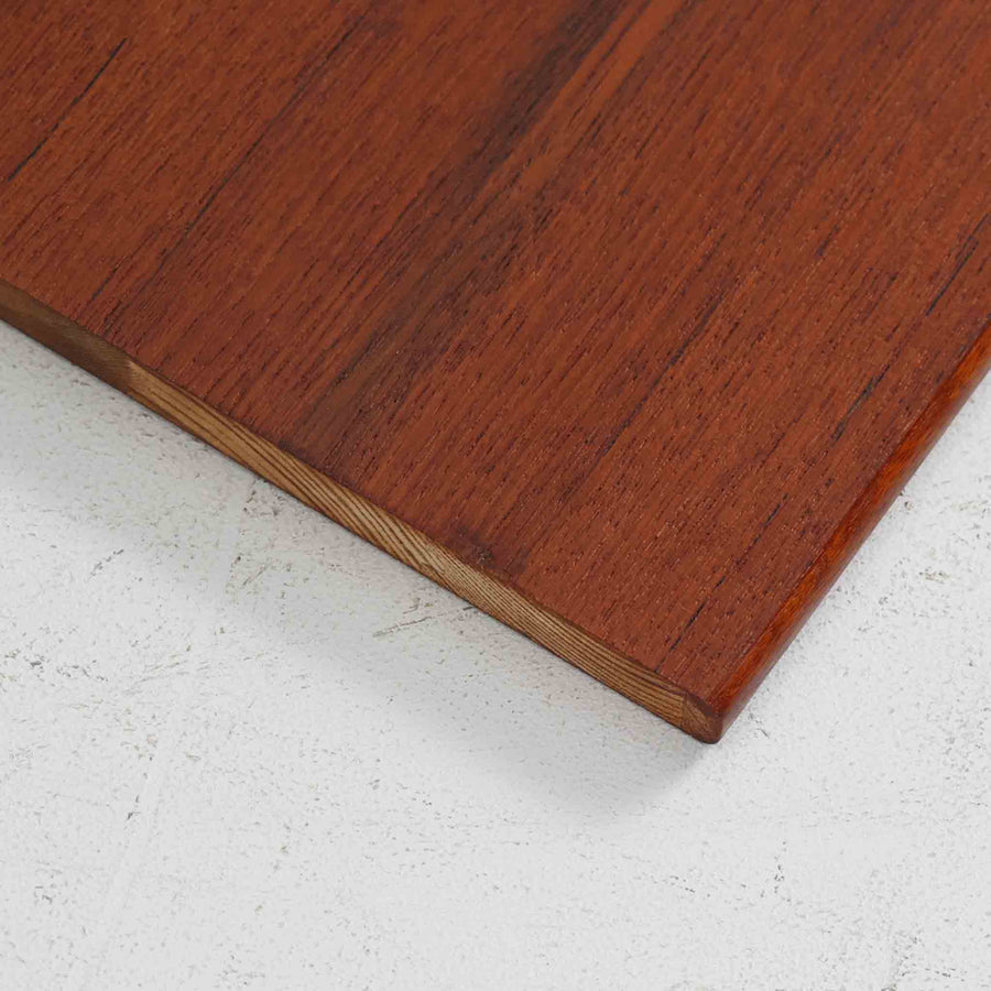 デンマークを代表するデザイナー、Borge Mogensen（ボーエ・モーエンセン）によるFDB社製のチーク材ブックシェルフです。無駄を削ぎ落とした直線的なフォルムと、シンプルで機能的なデザインがモーエンセンらしい魅力を感じさせます。棚板は高さ調整が可能で、収納するものに合わせて柔軟にレイアウトを変えることができます。チークの豊かな木目と深みのある色合いが上品な印象を与え、経年により増した艶や質感も味わい深い一点です。台輪部分までチーク材が使用された希少なタイプで、素材の統一感と高級感が際立ちます。リビングでの書籍収納はもちろん、オブジェや陶器を飾るディスプレイシェルフとしても活躍する北欧ビンテージ家具です。