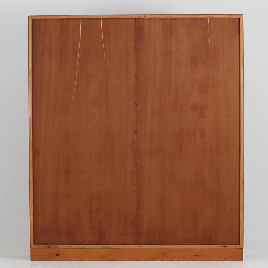 デンマークを代表するデザイナー、Borge Mogensen（ボーエ・モーエンセン）によるFDB社製のチーク材ブックシェルフです。無駄を削ぎ落とした直線的なフォルムと、シンプルで機能的なデザインがモーエンセンらしい魅力を感じさせます。棚板は高さ調整が可能で、収納するものに合わせて柔軟にレイアウトを変えることができます。チークの豊かな木目と深みのある色合いが上品な印象を与え、経年により増した艶や質感も味わい深い一点です。台輪部分までチーク材が使用された希少なタイプで、素材の統一感と高級感が際立ちます。リビングでの書籍収納はもちろん、オブジェや陶器を飾るディスプレイシェルフとしても活躍する北欧ビンテージ家具です。