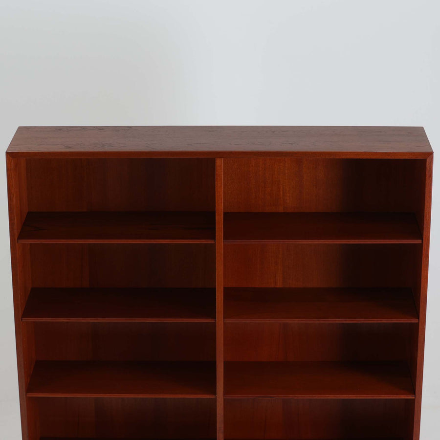 デンマークを代表するデザイナー、Borge Mogensen（ボーエ・モーエンセン）によるFDB社製のチーク材ブックシェルフです。無駄を削ぎ落とした直線的なフォルムと、シンプルで機能的なデザインがモーエンセンらしい魅力を感じさせます。棚板は高さ調整が可能で、収納するものに合わせて柔軟にレイアウトを変えることができます。チークの豊かな木目と深みのある色合いが上品な印象を与え、経年により増した艶や質感も味わい深い一点です。台輪部分までチーク材が使用された希少なタイプで、素材の統一感と高級感が際立ちます。リビングでの書籍収納はもちろん、オブジェや陶器を飾るディスプレイシェルフとしても活躍する北欧ビンテージ家具です。