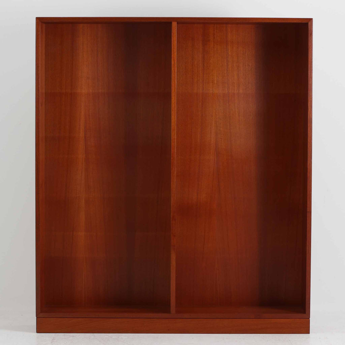 デンマークを代表するデザイナー、Borge Mogensen（ボーエ・モーエンセン）によるFDB社製のチーク材ブックシェルフです。無駄を削ぎ落とした直線的なフォルムと、シンプルで機能的なデザインがモーエンセンらしい魅力を感じさせます。棚板は高さ調整が可能で、収納するものに合わせて柔軟にレイアウトを変えることができます。チークの豊かな木目と深みのある色合いが上品な印象を与え、経年により増した艶や質感も味わい深い一点です。台輪部分までチーク材が使用された希少なタイプで、素材の統一感と高級感が際立ちます。リビングでの書籍収納はもちろん、オブジェや陶器を飾るディスプレイシェルフとしても活躍する北欧ビンテージ家具です。