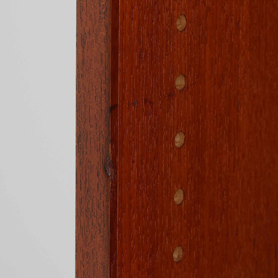 デンマークを代表するデザイナー、Borge Mogensen（ボーエ・モーエンセン）によるFDB社製のチーク材ブックシェルフです。無駄を削ぎ落とした直線的なフォルムと、シンプルで機能的なデザインがモーエンセンらしい魅力を感じさせます。棚板は高さ調整が可能で、収納するものに合わせて柔軟にレイアウトを変えることができます。チークの豊かな木目と深みのある色合いが上品な印象を与え、経年により増した艶や質感も味わい深い一点です。台輪部分までチーク材が使用された希少なタイプで、素材の統一感と高級感が際立ちます。リビングでの書籍収納はもちろん、オブジェや陶器を飾るディスプレイシェルフとしても活躍する北欧ビンテージ家具です。