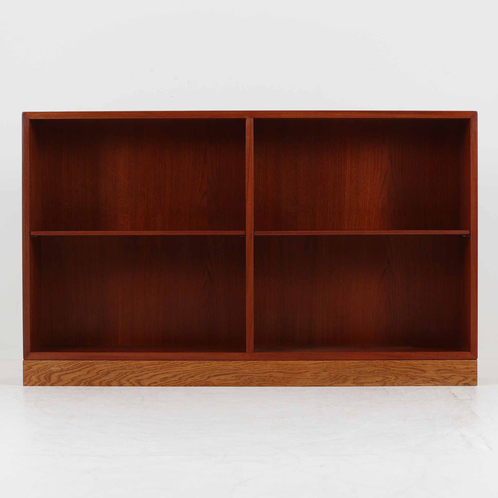 Borge Mogensen（ボーエ・モーエンセン）によるFDB社製のブックシェルフです。チーク材とオーク材を組み合わせた構造で、温かみのある色合いと堅牢な造りが魅力です。幅122cmのワイドなサイズで、書籍や雑誌の収納はもちろん、オブジェやコレクションのディスプレイにも適しています。シンプルで直線的なフォルムは北欧家具らしい機能美を感じさせ、経年によって増した深い色艶がビンテージならではの存在感を放ちます。書斎やリビングにおいて実用性と美観を兼ね備えた一台です。