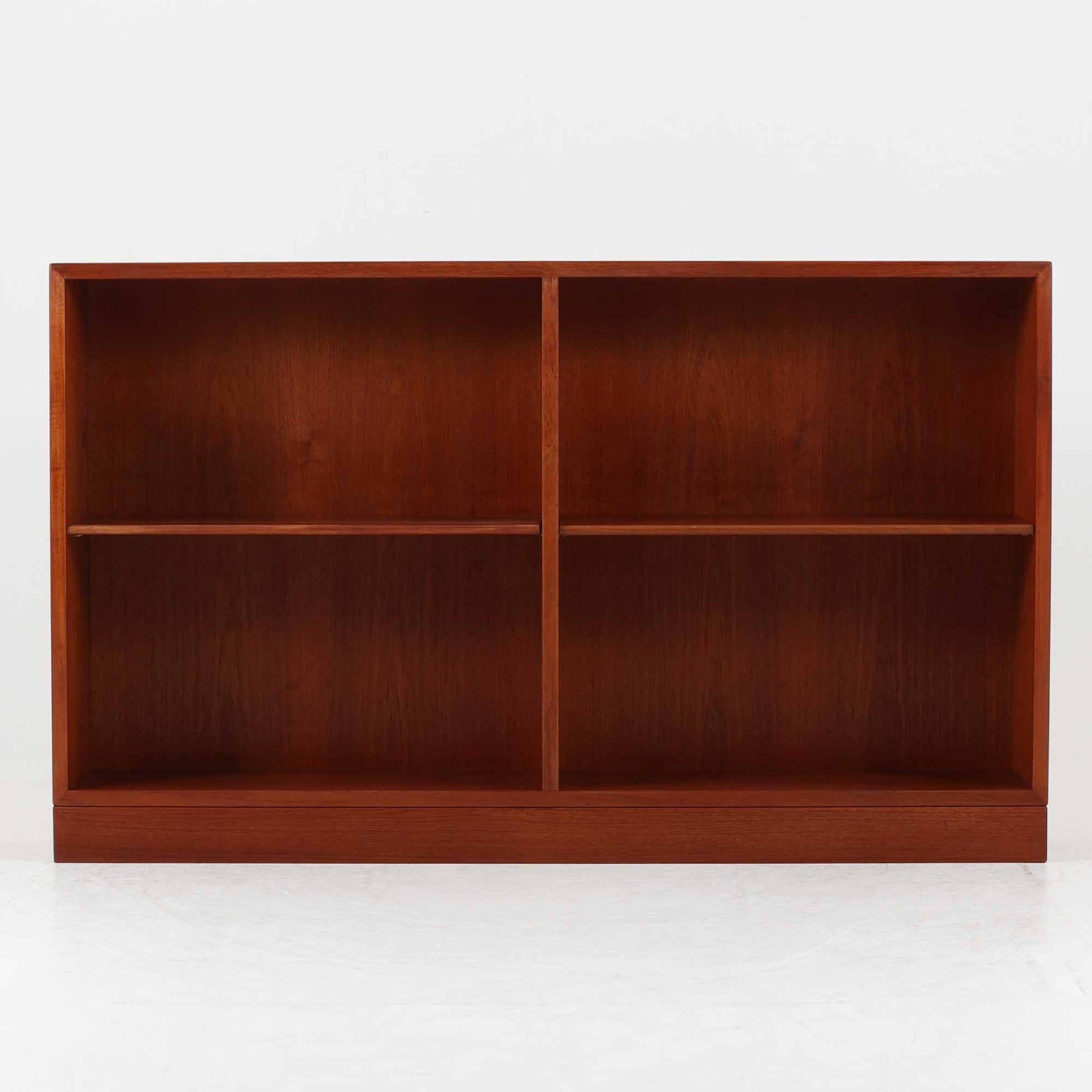 Borge Mogensen（ボーエ・モーエンセン）によるFDB社製のブックシェルフです。幅122cmのゆとりあるサイズで、シンプルな直線構造が北欧家具らしい機能美を感じさせます。チーク材の温かみある木目が際立ち、経年による深みを増した色艶がビンテージならではの存在感を演出します。可動棚仕様により収納の自由度が高く、書籍や雑誌はもちろん、オブジェや日用品の整理にも適しています。堅牢な造りと端正なデザインが空間に落ち着いた雰囲気をもたらす一台です。