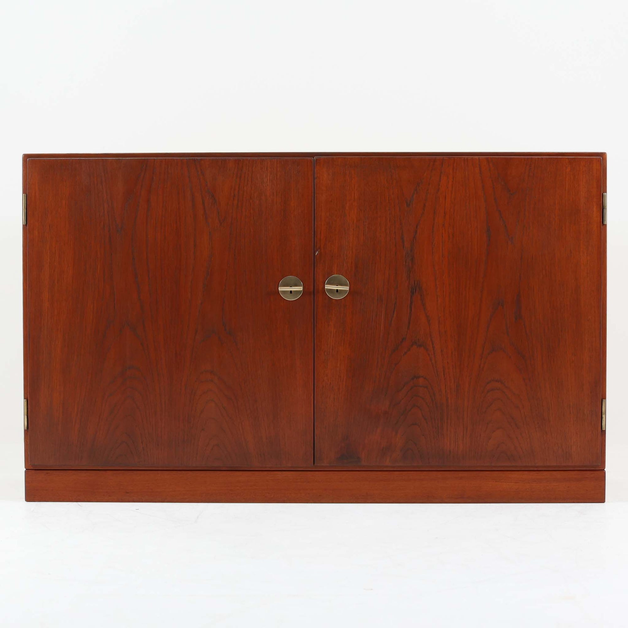 Borge Mogensenがデザインし、FDB Moblerにより製作されたModel 232のキャビネットです。チーク材の美しい木目を活かした端正な外観と、鍵がそのまま取っ手として機能するユニークな構造が特徴です。内部には引き出しと棚板が備えられ、位置調整や取り外しが可能なため用途に合わせて柔軟に収納できます。幅122cmの扱いやすいサイズで、リビングや書斎など様々な空間で活躍する、実用性と北欧デザインの魅力を兼ね備えたビンテージ家具です。