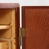 Borge Mogensenがデザインし、FDB Moblerにより製作されたModel 232のキャビネットです。チーク材の美しい木目を活かした端正な外観と、鍵がそのまま取っ手として機能するユニークな構造が特徴です。内部には引き出しと棚板が備えられ、位置調整や取り外しが可能なため用途に合わせて柔軟に収納できます。幅122cmの扱いやすいサイズで、リビングや書斎など様々な空間で活躍する、実用性と北欧デザインの魅力を兼ね備えたビンテージ家具です。