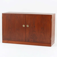 Borge Mogensenがデザインし、FDB Moblerにより製作されたModel 232のキャビネットです。チーク材の美しい木目を活かした端正な外観と、鍵がそのまま取っ手として機能するユニークな構造が特徴です。内部には引き出しと棚板が備えられ、位置調整や取り外しが可能なため用途に合わせて柔軟に収納できます。幅122cmの扱いやすいサイズで、リビングや書斎など様々な空間で活躍する、実用性と北欧デザインの魅力を兼ね備えたビンテージ家具です。