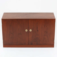 Borge Mogensenがデザインし、FDB Moblerにより製作されたModel 232のキャビネットです。チーク材の美しい木目を活かした端正な外観と、鍵がそのまま取っ手として機能するユニークな構造が特徴です。内部には引き出しと棚板が備えられ、位置調整や取り外しが可能なため用途に合わせて柔軟に収納できます。幅122cmの扱いやすいサイズで、リビングや書斎など様々な空間で活躍する、実用性と北欧デザインの魅力を兼ね備えたビンテージ家具です。