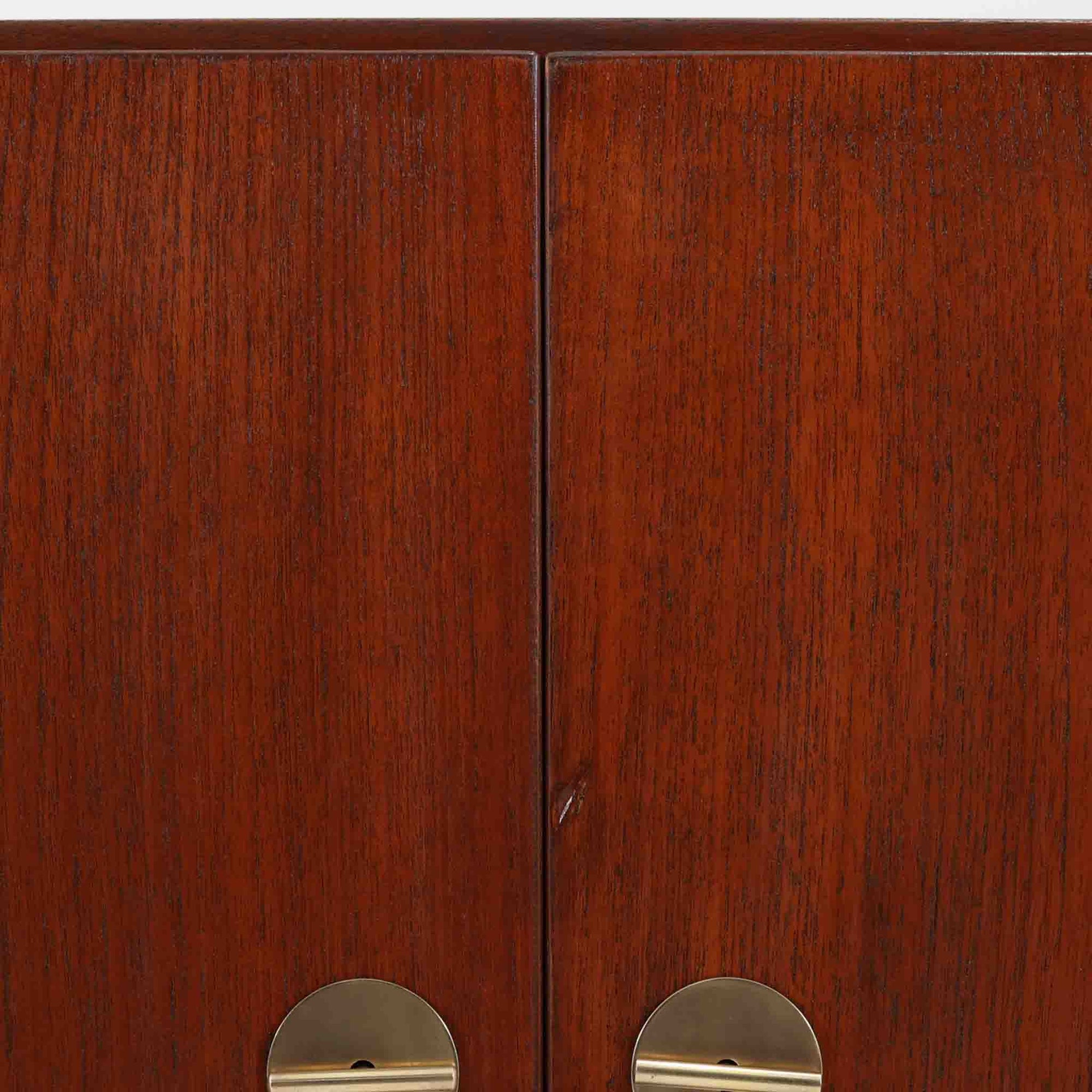 Borge Mogensenがデザインし、FDB Moblerにより製作されたModel 232のキャビネットです。チーク材の美しい木目を活かした端正な外観と、鍵がそのまま取っ手として機能するユニークな構造が特徴です。内部には引き出しと棚板が備えられ、位置調整や取り外しが可能なため用途に合わせて柔軟に収納できます。幅122cmの扱いやすいサイズで、リビングや書斎など様々な空間で活躍する、実用性と北欧デザインの魅力を兼ね備えたビンテージ家具です。