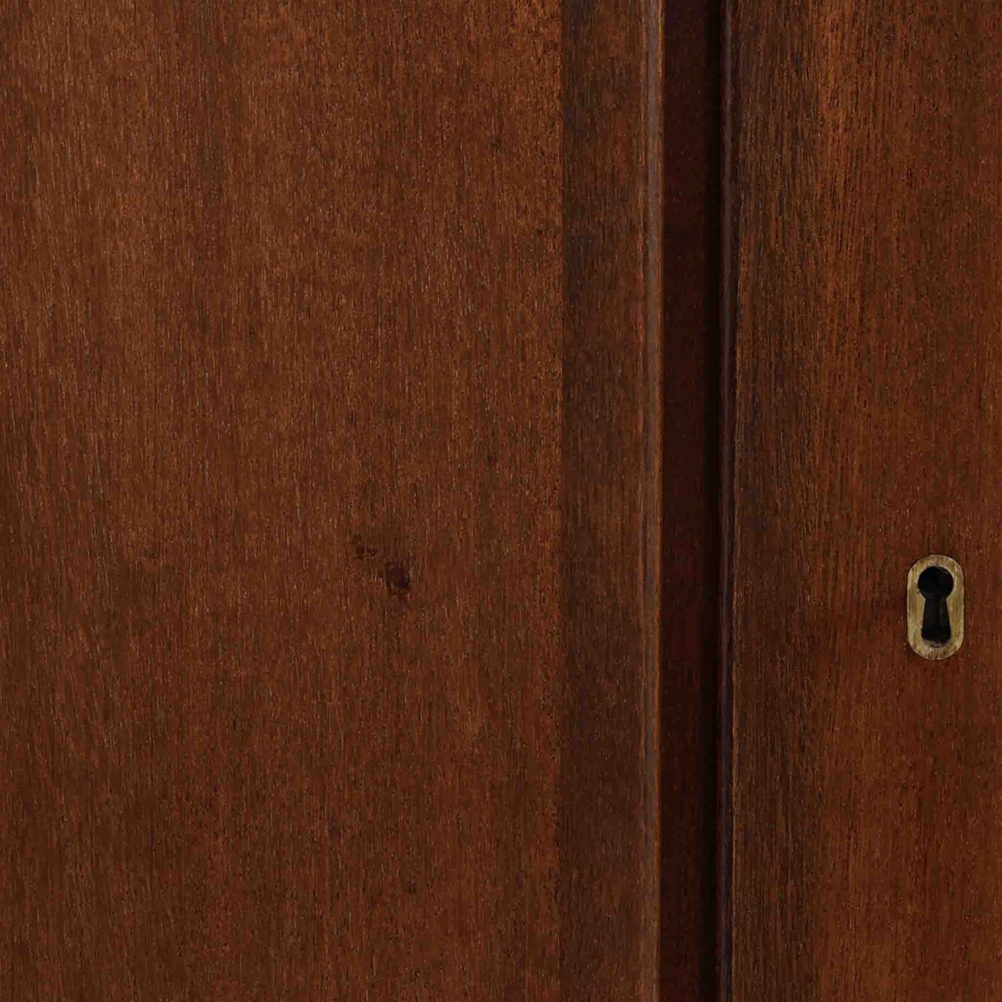 Ole Wanscher（オーレ・ヴァンシャー）がデザインし、P.Jeppesen社より製造された「Rungstedlund」キャビネットです。端正な直線構成と細く伸びた脚部が特徴で、マホガニー材特有の深い色調と気品ある木目が空間に落ち着きをもたらします。内部は棚板とトレイが効率よく配置され、食器から書類収納まで幅広く活用可能。上質な素材使いと精巧な造り込みはヴァンシャー作品ならではで、経年により全体に落ち着いた色調へと変化しており、現地デンマークのオークションで入手した確かな出自を持つ個体です。