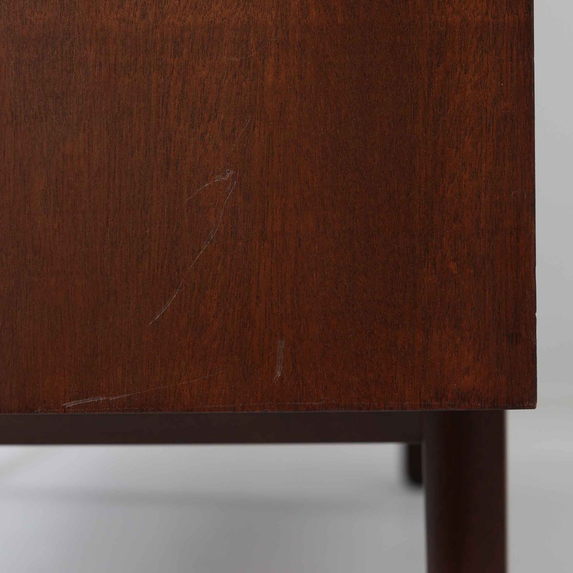 Ole Wanscher（オーレ・ヴァンシャー）がデザインし、P.Jeppesen社より製造された「Rungstedlund」キャビネットです。端正な直線構成と細く伸びた脚部が特徴で、マホガニー材特有の深い色調と気品ある木目が空間に落ち着きをもたらします。内部は棚板とトレイが効率よく配置され、食器から書類収納まで幅広く活用可能。上質な素材使いと精巧な造り込みはヴァンシャー作品ならではで、経年により全体に落ち着いた色調へと変化しており、現地デンマークのオークションで入手した確かな出自を持つ個体です。