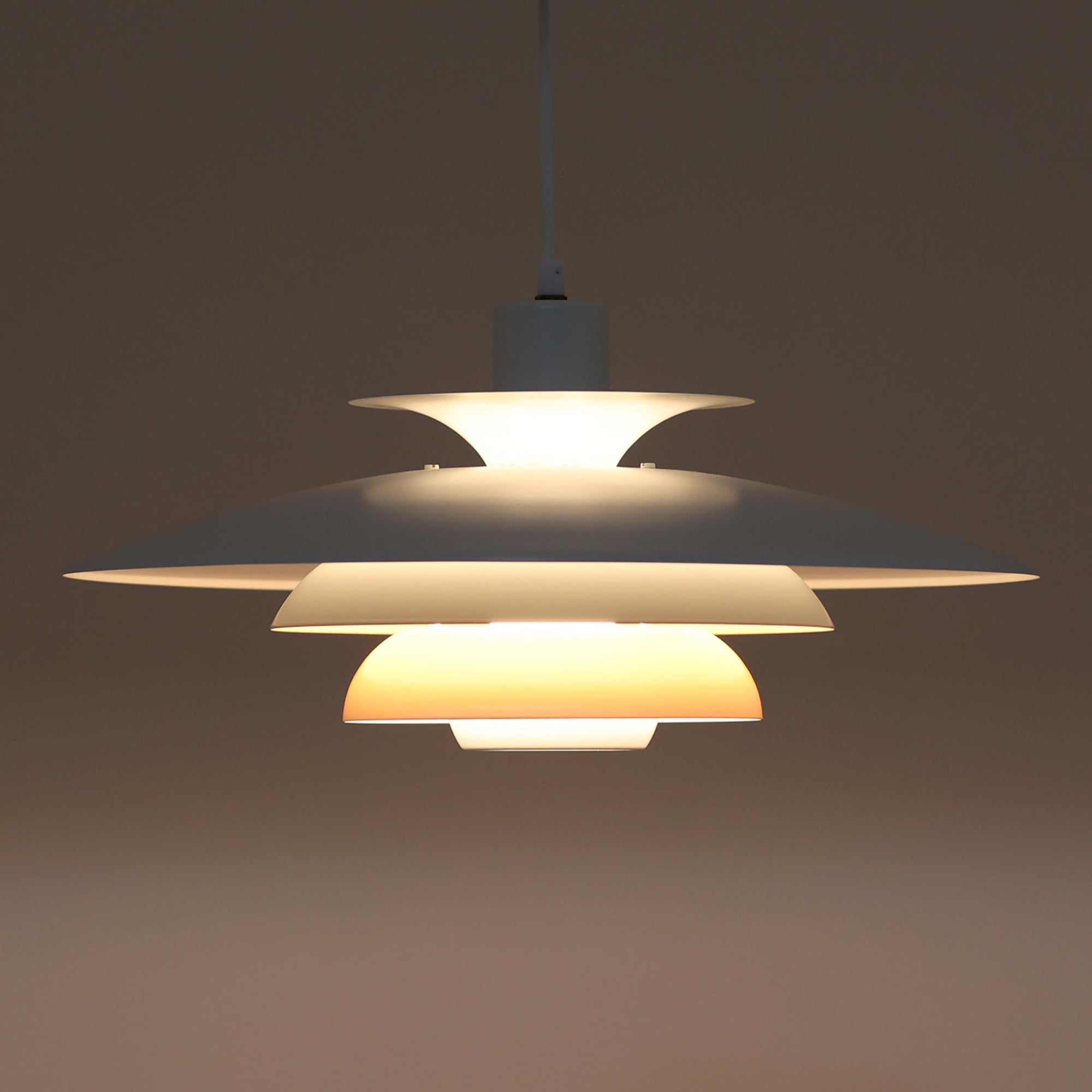 Jeka Metaltryk社製のペンダントライト「Sofie」です。直径48cmと大きめのサイズで、複数枚のシェードを重ねた構造が特徴的です。スチール素材のしっかりとした造りで、点灯時には光が柔らかく分散し、眩しさを抑えつつ空間を明るく照らします。内側に施された温かみのある色合いが、照明に柔らかなニュアンスを加え、ダイニングやリビングのメインライトとして存在感を放ちます。シンプルながらも洗練された北欧デザインを感じさせるビンテージアイテムです。