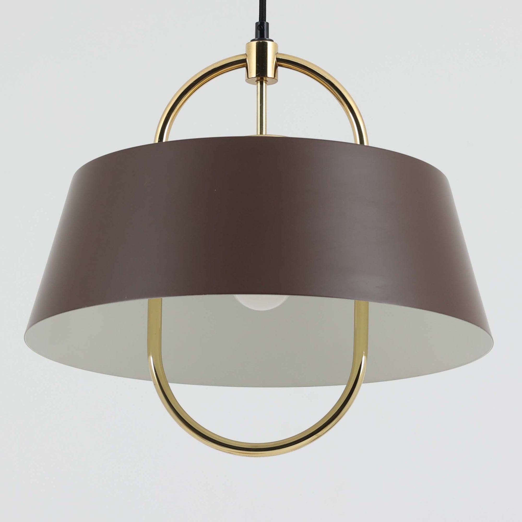 Jo HammerborgがFog &amp; Morup社のためにデザインした「Hercules」ペンダントライトです。直径42cmのサイズで、落ち着いたブラウンのアルミシェードに真鍮製のアーチが美しく組み合わさったデザインが特徴です。点灯時にはシェードの下方から柔らかな光を広げるとともに、真鍮の輝きが上品なアクセントとなり、空間をモダンかつ華やかに演出します。ダイニングやリビングのメイン照明として存在感を放ち、北欧ビンテージならではの独特な雰囲気を楽しめる逸品です。