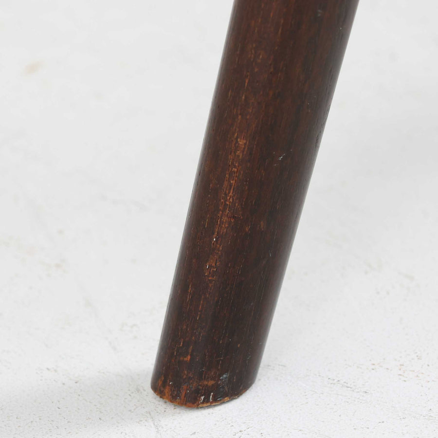 デンマークのデザイナー、Kai Kristiansen（カイ・クリスチャンセン）による「コンパスチェア」。SVA Mobler社より製造された代表作のひとつです。名の通りコンパスの脚を思わせる美しい角度を持つフレーム構造が特徴で、木部にはステイン塗装された濃い色味のオーク材が使用されています。背もたれからアームへと流れるようなラインが柔らかく、身体を包み込むような快適な座り心地を実現。落ち着いたグレーの張地が空間に馴染みます。北欧デザインの美と機能が融合した名作チェアです。