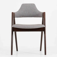 デンマークのデザイナー、Kai Kristiansen（カイ・クリスチャンセン）による「コンパスチェア」。SVA Mobler社より製造された代表作のひとつです。名の通りコンパスの脚を思わせる美しい角度を持つフレーム構造が特徴で、木部にはステイン塗装された濃い色味のオーク材が使用されています。背もたれからアームへと流れるようなラインが柔らかく、身体を包み込むような快適な座り心地を実現。落ち着いたグレーの張地が空間に馴染みます。北欧デザインの美と機能が融合した名作チェアです。