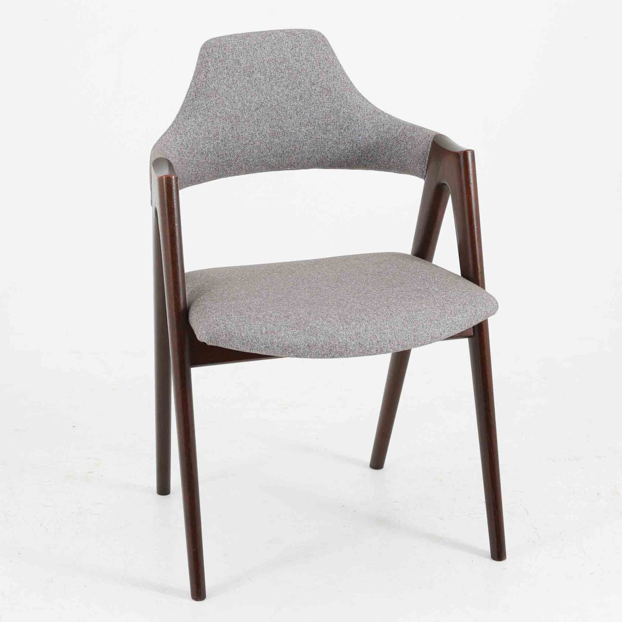 デンマークのデザイナー、Kai Kristiansen（カイ・クリスチャンセン）による「コンパスチェア」。SVA Mobler社より製造された代表作のひとつです。名の通りコンパスの脚を思わせる美しい角度を持つフレーム構造が特徴で、木部にはステイン塗装された濃い色味のオーク材が使用されています。背もたれからアームへと流れるようなラインが柔らかく、身体を包み込むような快適な座り心地を実現。落ち着いたグレーの張地が空間に馴染みます。北欧デザインの美と機能が融合した名作チェアです。