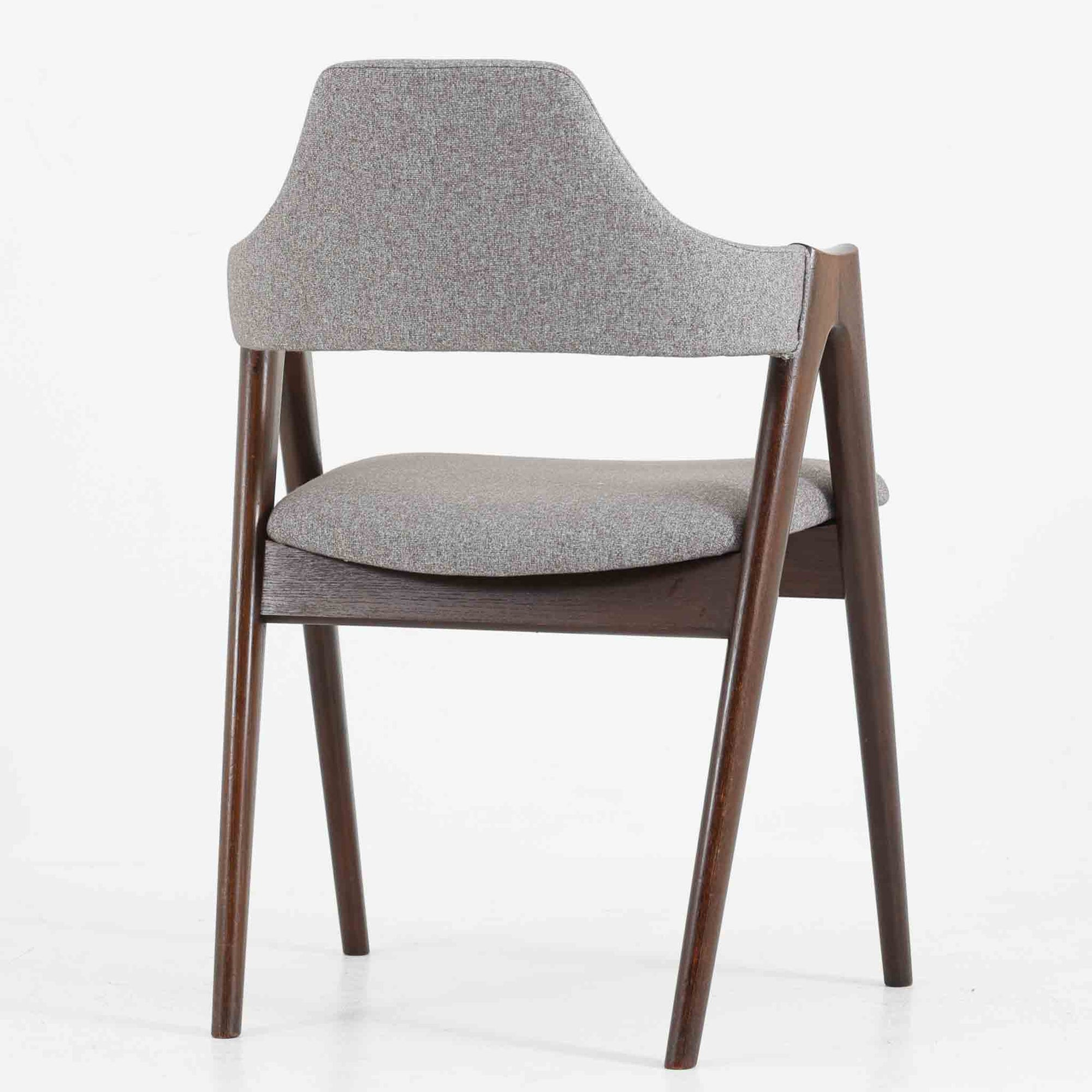 デンマークのデザイナー、Kai Kristiansen（カイ・クリスチャンセン）による「コンパスチェア」。SVA Mobler社より製造された代表作のひとつです。名の通りコンパスの脚を思わせる美しい角度を持つフレーム構造が特徴で、木部にはステイン塗装された濃い色味のオーク材が使用されています。背もたれからアームへと流れるようなラインが柔らかく、身体を包み込むような快適な座り心地を実現。落ち着いたグレーの張地が空間に馴染みます。北欧デザインの美と機能が融合した名作チェアです。