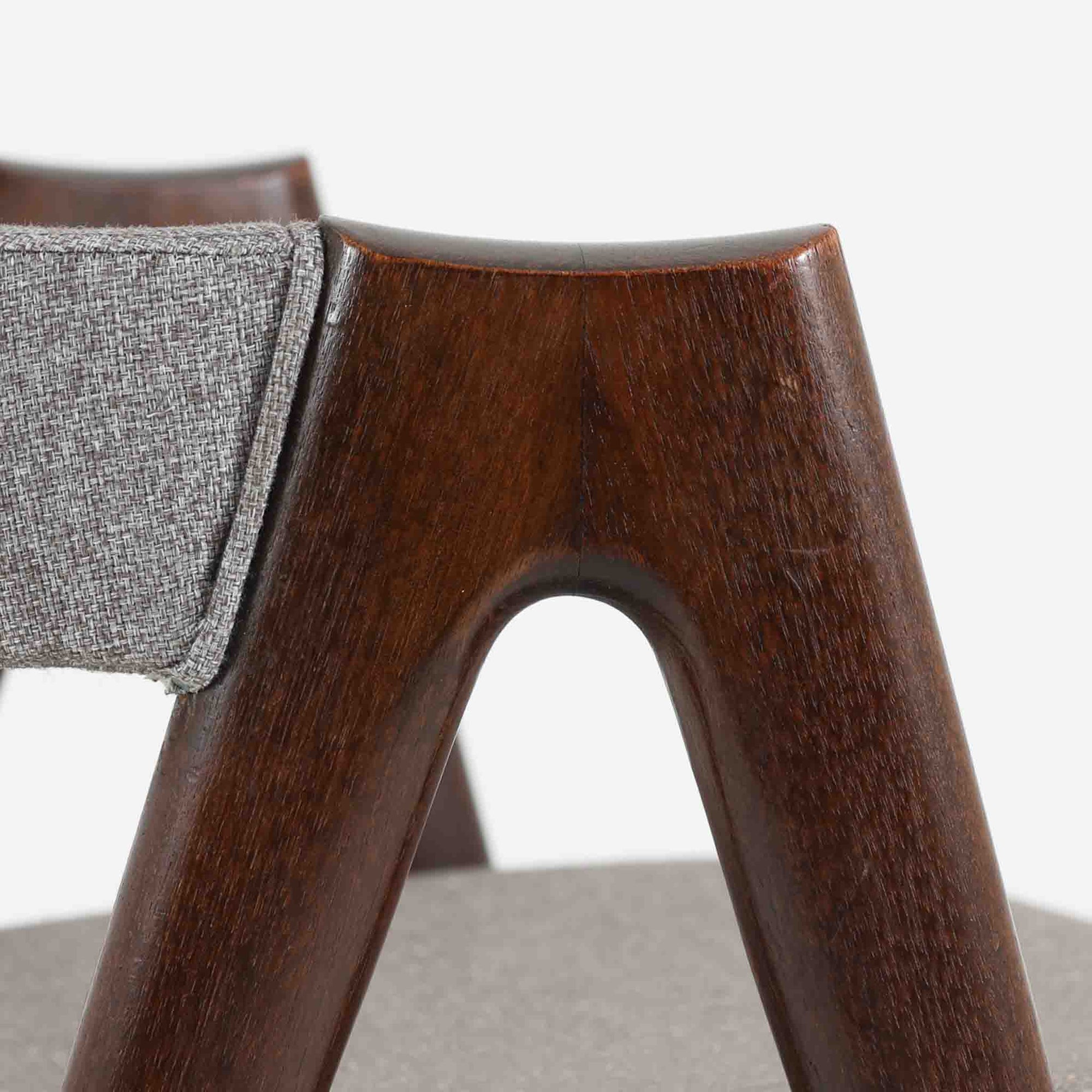 デンマークのデザイナー、Kai Kristiansen（カイ・クリスチャンセン）による「コンパスチェア」。SVA Mobler社より製造された代表作のひとつです。名の通りコンパスの脚を思わせる美しい角度を持つフレーム構造が特徴で、木部にはステイン塗装された濃い色味のオーク材が使用されています。背もたれからアームへと流れるようなラインが柔らかく、身体を包み込むような快適な座り心地を実現。落ち着いたグレーの張地が空間に馴染みます。北欧デザインの美と機能が融合した名作チェアです。