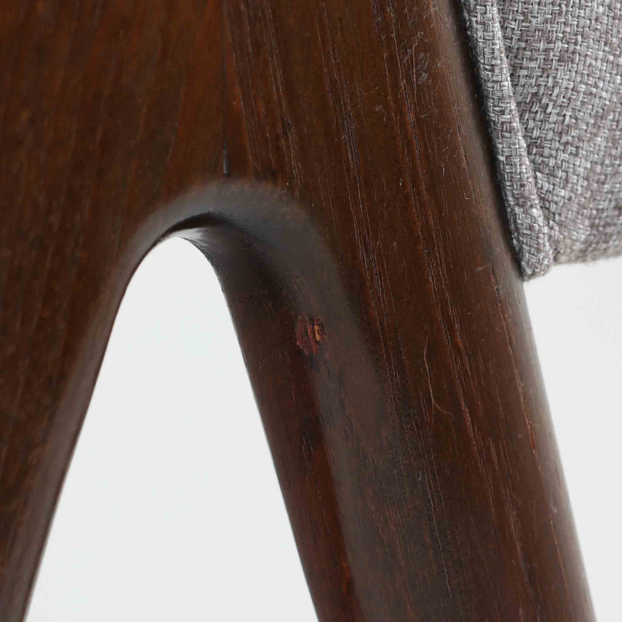 デンマークのデザイナー、Kai Kristiansen（カイ・クリスチャンセン）による「コンパスチェア」。SVA Mobler社より製造された代表作のひとつです。名の通りコンパスの脚を思わせる美しい角度を持つフレーム構造が特徴で、木部にはステイン塗装された濃い色味のオーク材が使用されています。背もたれからアームへと流れるようなラインが柔らかく、身体を包み込むような快適な座り心地を実現。落ち着いたグレーの張地が空間に馴染みます。北欧デザインの美と機能が融合した名作チェアです。