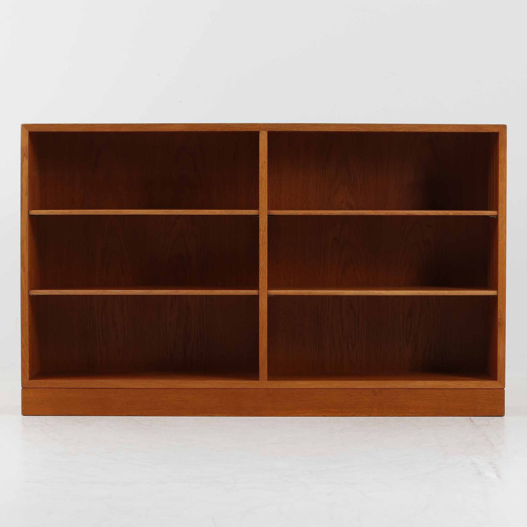 Borge Mogensen（ボーエ・モーエンセン）によるFDB社製のブックシェルフです。良質なオーク材で、温かみのある色合いと堅牢な造りが魅力です。幅122cmのワイドなサイズで、書籍や雑誌の収納はもちろん、オブジェやコレクションのディスプレイにも適しています。シンプルで直線的なフォルムは北欧家具らしい機能美を感じさせ、経年によって増した深い色艶がビンテージならではの存在感を放ちます。書斎やリビングにおいて実用性と美観を兼ね備えた一台です。