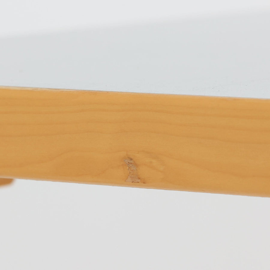 Alvar AaltoがデザインしArtek社より製造されたこちらのダイニングテーブルは、天板に落ち着いたグレートーンのリノリウム、脚部に美しい木肌のバーチ材を用いた北欧モダンデザインの名作で、L字型に曲げられた脚部がアアルトらしい柔らかな造形美を感じさせます。幅120cmの使い勝手のよいサイズ感で、ダイニングやワークスペースにもしっくりと馴染み、機能美と素材感のバランスに優れた一台です。