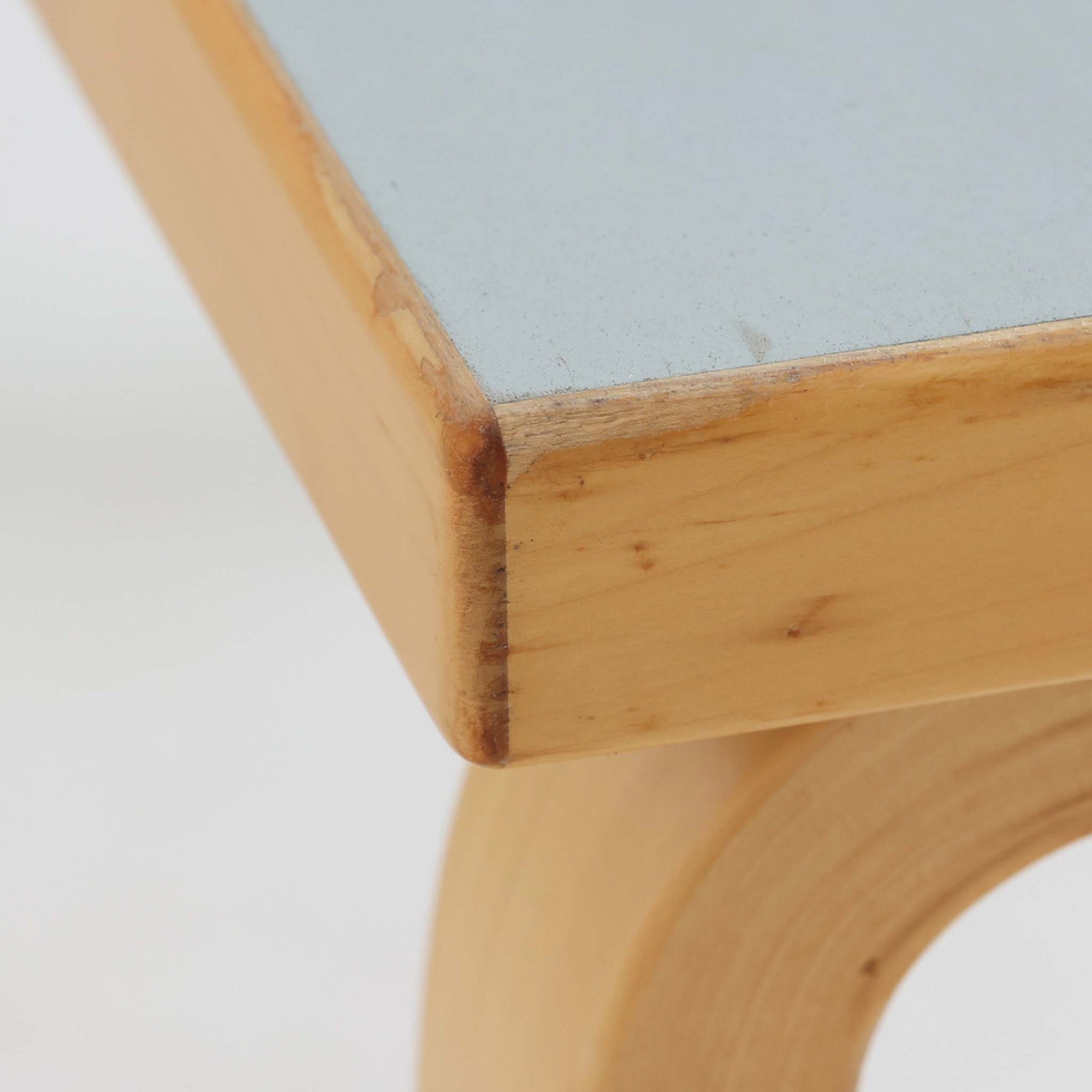 Alvar AaltoがデザインしArtek社より製造されたこちらのダイニングテーブルは、天板に落ち着いたグレートーンのリノリウム、脚部に美しい木肌のバーチ材を用いた北欧モダンデザインの名作で、L字型に曲げられた脚部がアアルトらしい柔らかな造形美を感じさせます。幅120cmの使い勝手のよいサイズ感で、ダイニングやワークスペースにもしっくりと馴染み、天板裏面には脚の付け替え跡が見られ、アアルト製品が多く採用されていたデンマークの公共施設で丁寧に使用されていた個体です。機能美と素材感のバランスに優れた一台です。